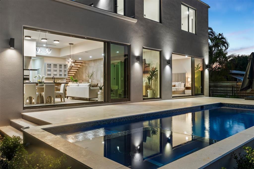 1212 AVOCADO Isle, Fort Lauderdale, Fort Lauderdale, FL 33315 Swimming pool with tiled interior, expansive paved patio, and contemporary exterior wall lighting