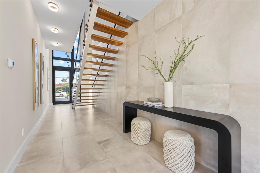 1212 AVOCADO Isle, Fort Lauderdale, Fort Lauderdale, FL 33315 Floating staircase with wood treads and glass railing, large format tile flooring, full-light entry door, and recessed ceiling lighting