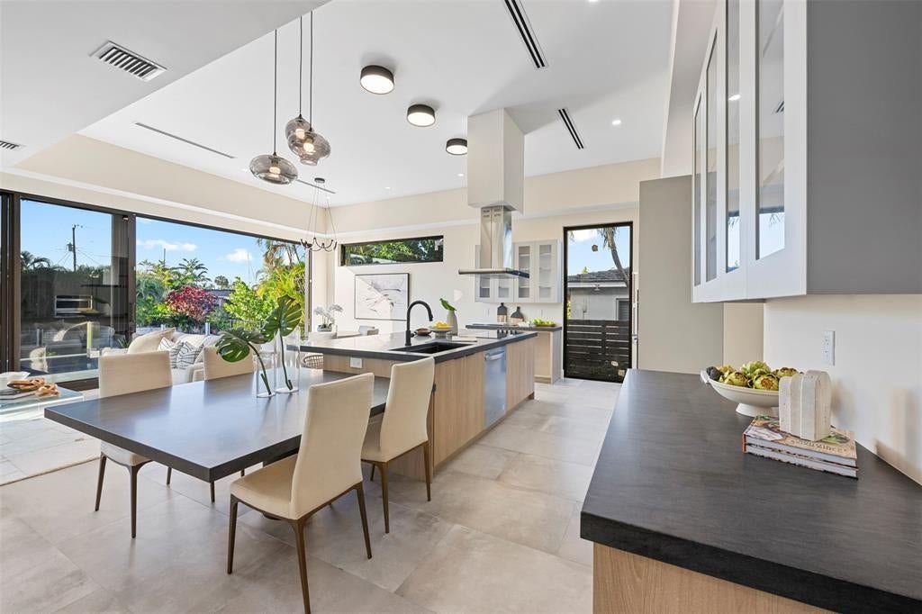 1212 AVOCADO Isle, Fort Lauderdale, Fort Lauderdale, FL 33315 Expansive sliding glass doors, contemporary kitchen island with seating, dark countertops, light wood-finish cabinetry, and recessed lighting