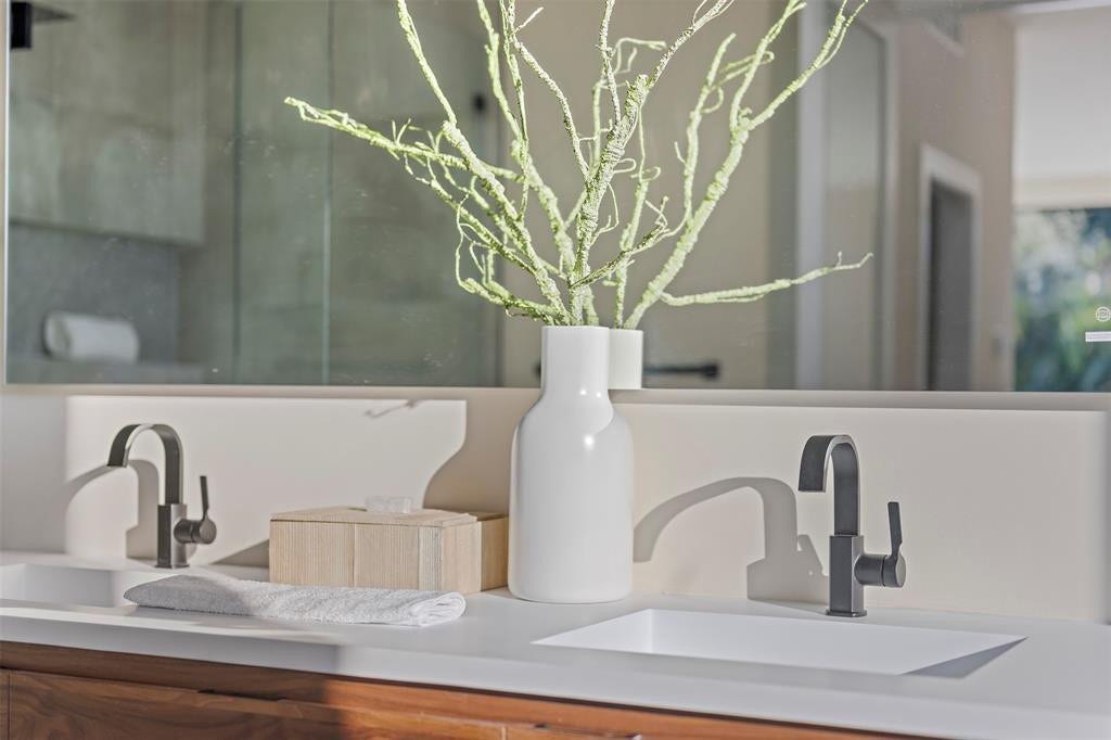 1212 AVOCADO Isle, Fort Lauderdale, Fort Lauderdale, FL 33315 Dual integrated sinks with matte black fixtures, set into a light-toned countertop, with wood-finish vanity cabinetry