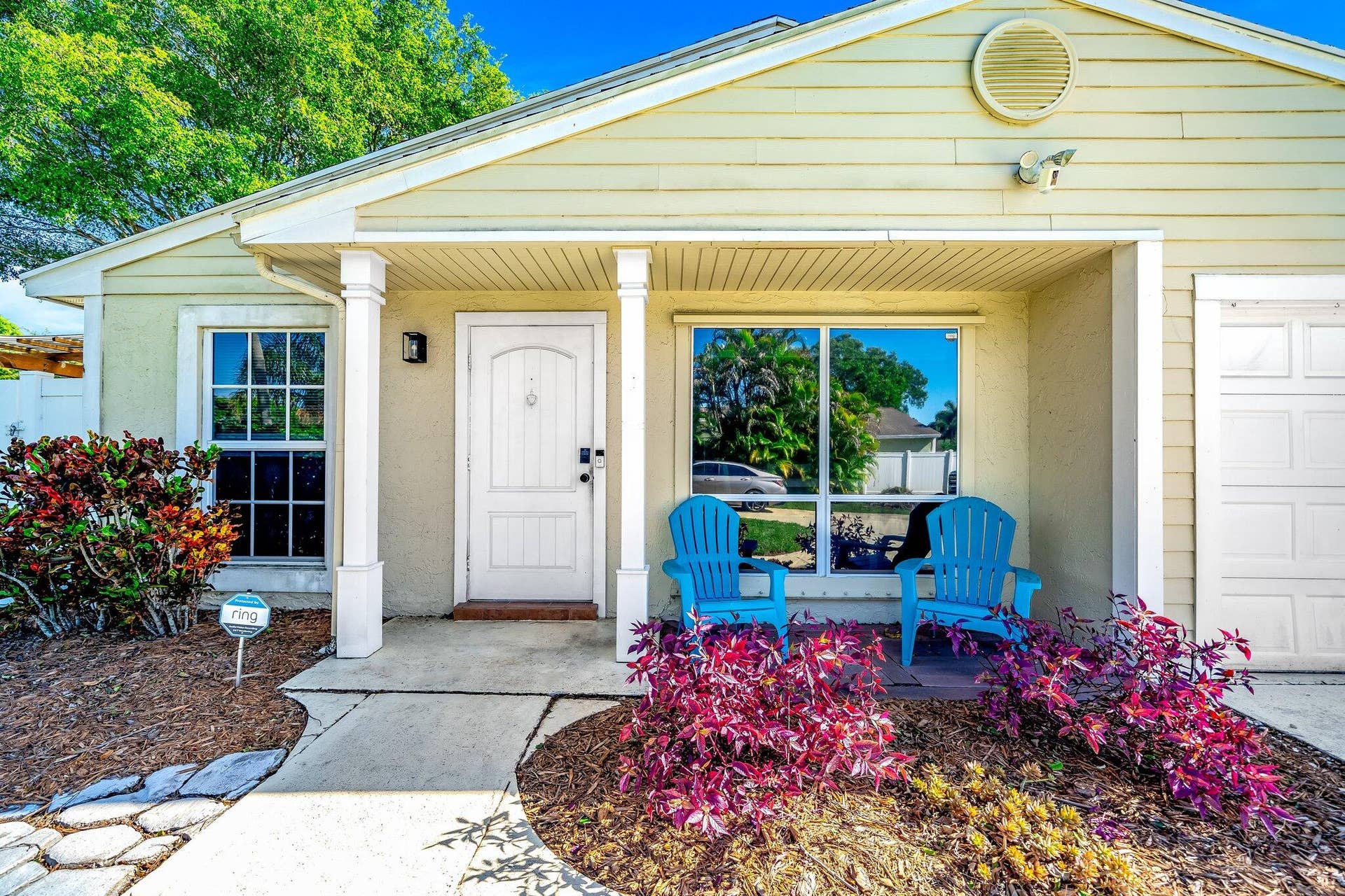 Covered front entry with white columns, arched front door, and adjacent garage - was converted to a room and can be converted back