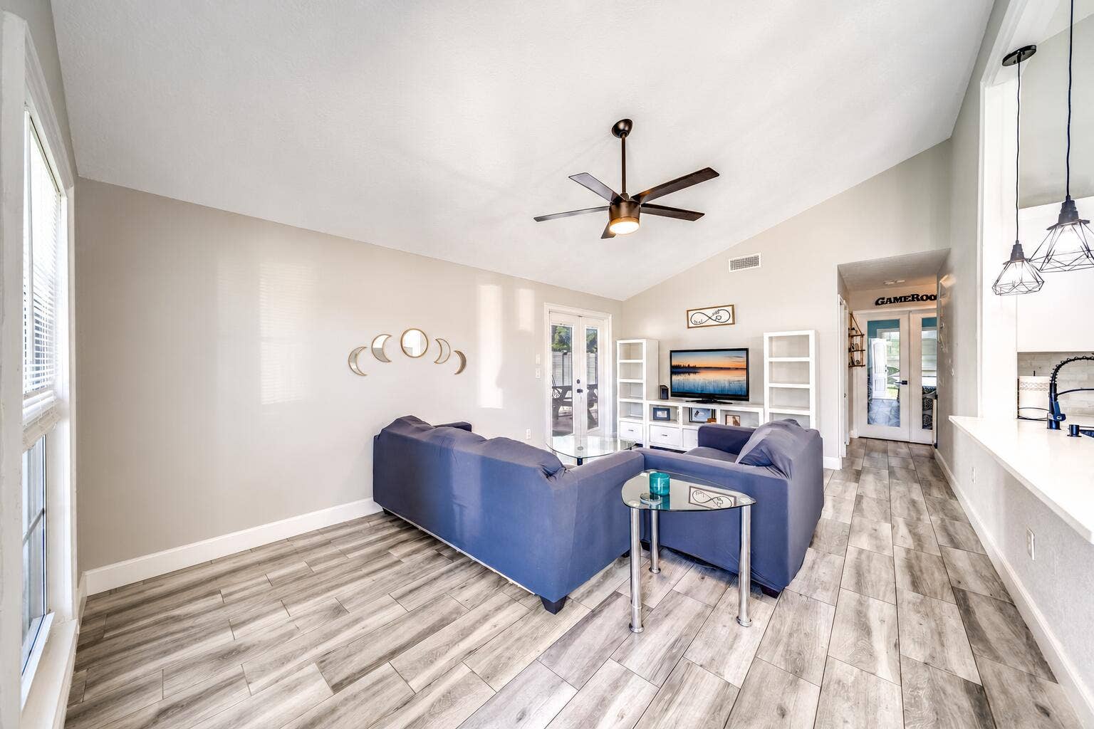 Vaulted ceilings, wood-finish flooring, ceiling fan, and French doors