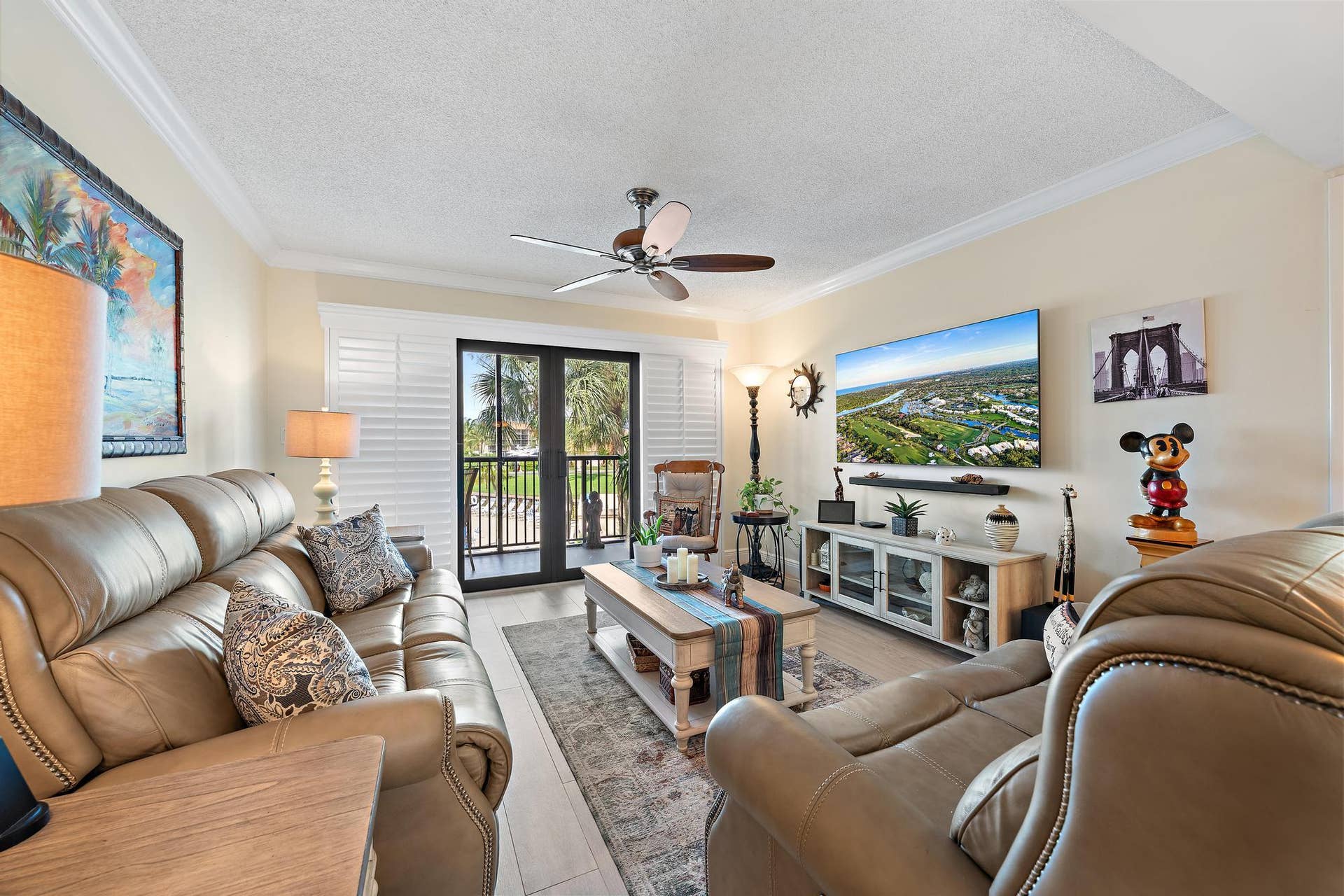 Living area featuring crown molding and a ceiling fan.