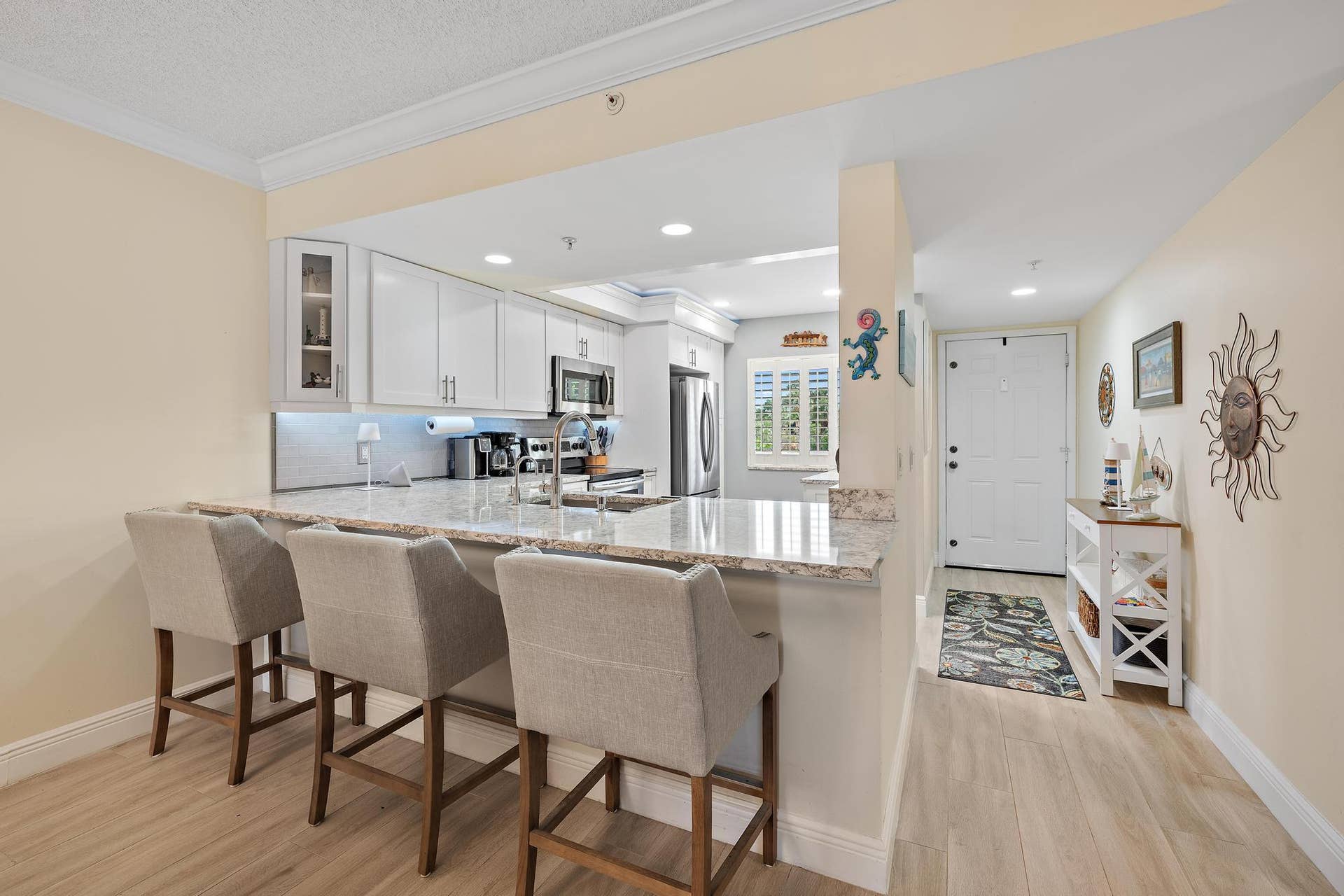 Kitchen featuring white cabinetry, stainless steel appliances, and a breakfast bar with quartz countertops