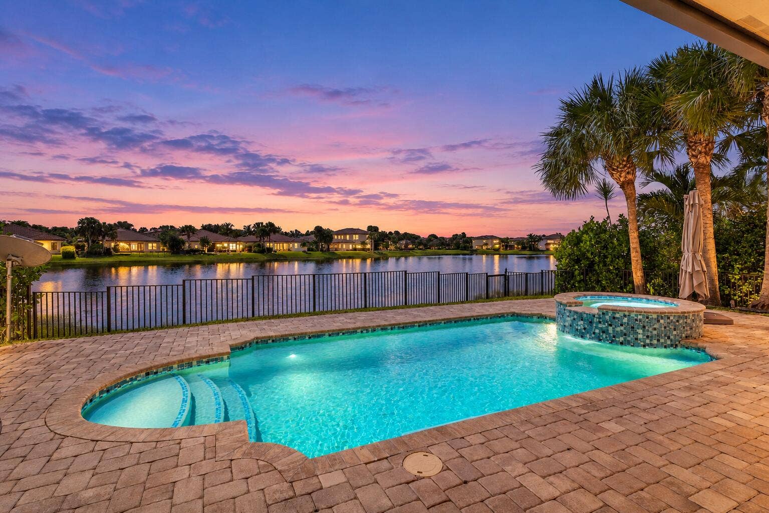 Elegant twilight home with glowing pool-
