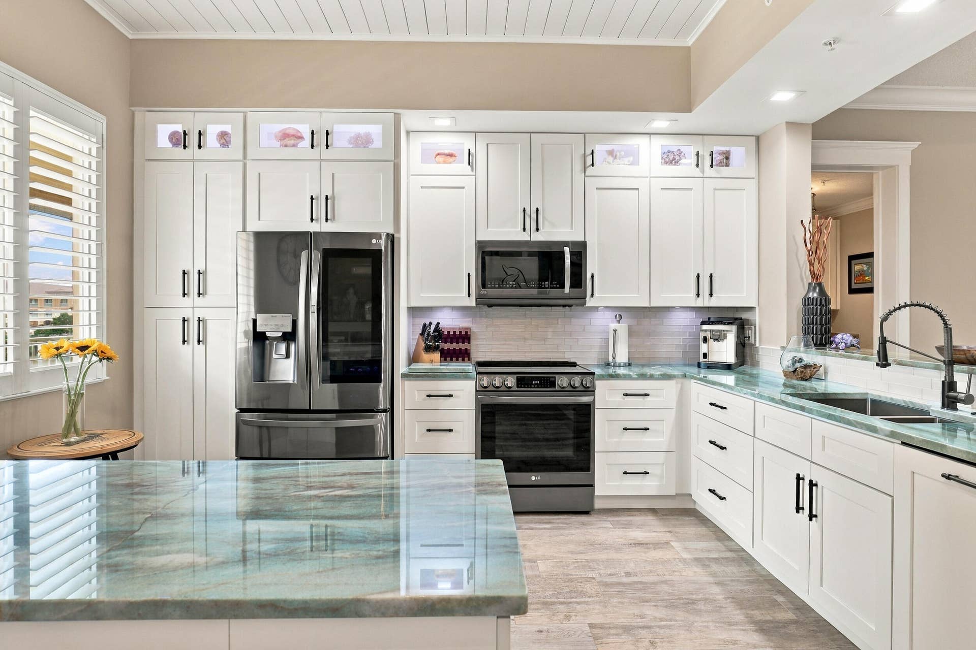 Soft Close Wood Cabinetry with Black Hardware and Pull-Out Shelving. Under Counter Drawers Substituted for Cabinets to Provide Easier Access to Every Day Items
