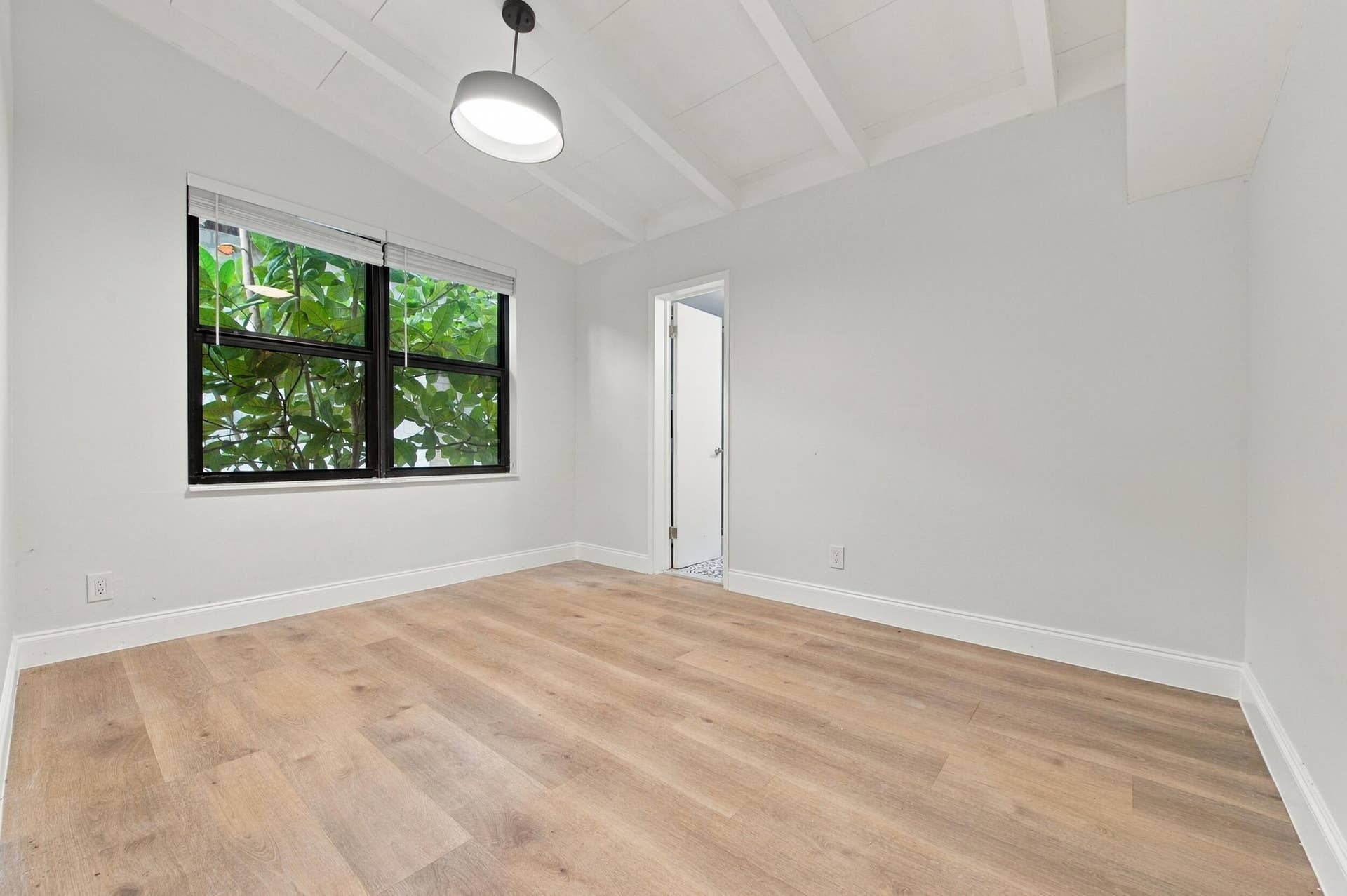 2536 GULFSTREAM Lane, Fort Lauderdale, FL 33312 Vaulted ceiling with exposed beams, wood-finish flooring, recessed window with black frame, and a white flush-mount light fixture