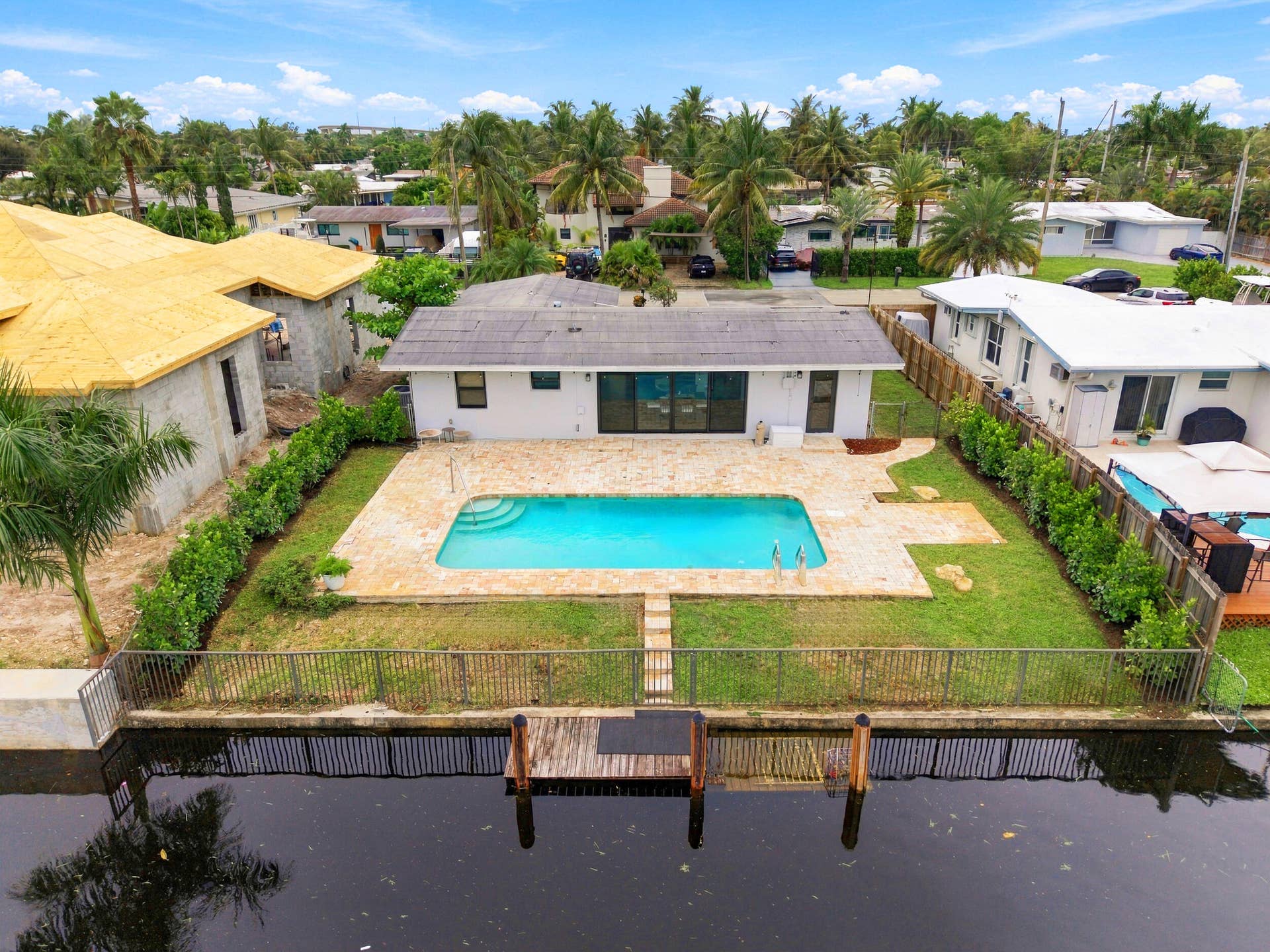 2536 GULFSTREAM Lane, Fort Lauderdale, FL 33312 Waterfront property featuring a private dock, inground swimming pool, expansive backyard, mature landscaping, and sliding glass doors