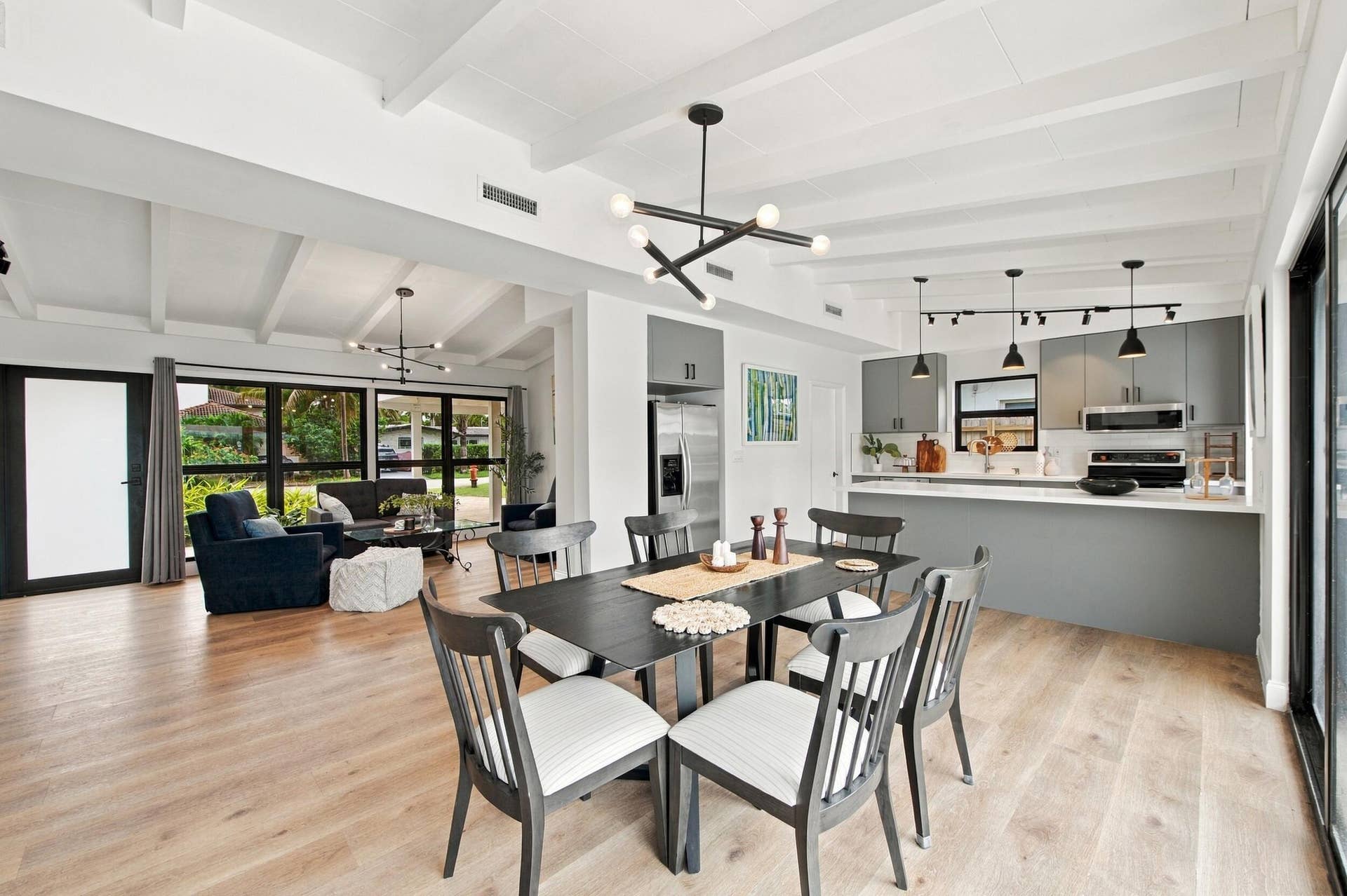 2536 GULFSTREAM Lane, Fort Lauderdale, FL 33312 Vaulted ceilings with exposed beams, wood-finish flooring, full-height windows, a modern kitchen with gray cabinetry, and stainless steel appliances
