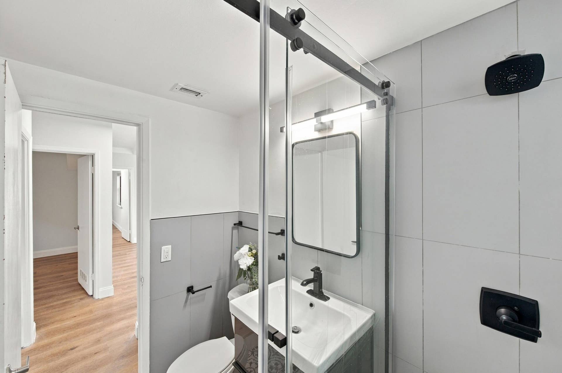 2536 GULFSTREAM Lane, Fort Lauderdale, FL 33312 Bathroom featuring a glass barn door shower enclosure, wall-mounted shower head, vanity with integrated sink, and modern mirror with overhead lighting