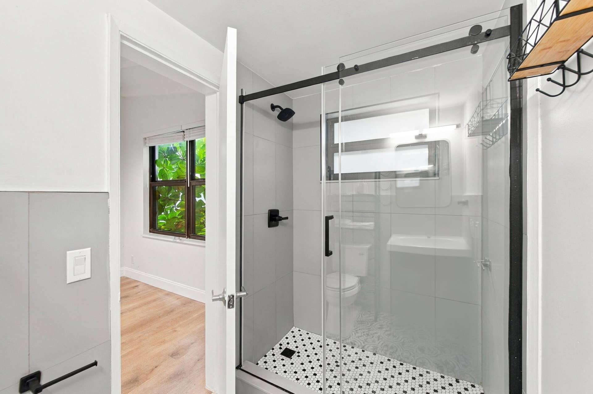 2536 GULFSTREAM Lane, Fort Lauderdale, FL 33312 Glass-enclosed shower with black-framed sliding door and contrasting black and white mosaic tile flooring