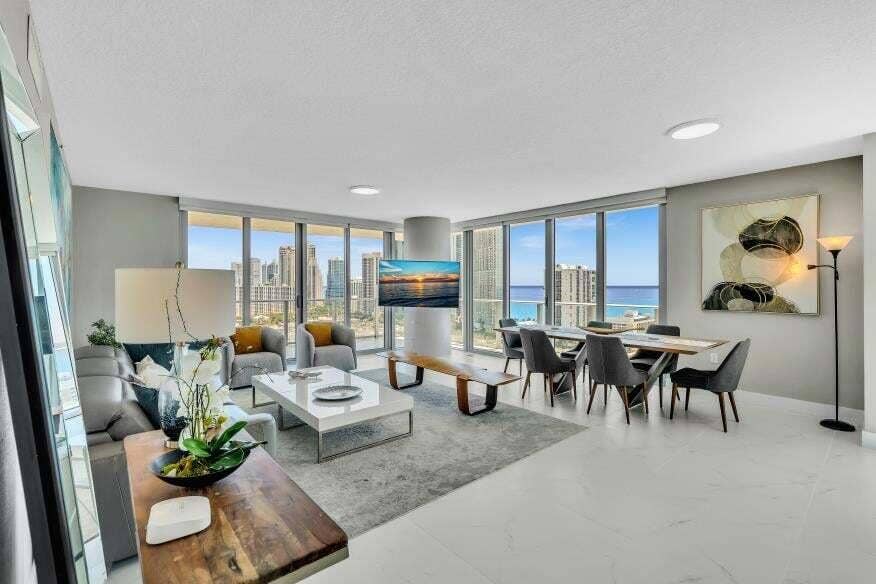 Sunny Isles Beach, Sunny Isles Beach, FL 33160 Expansive living area with large format tile flooring, extensive floor-to-ceiling windows, and recessed ceiling lighting