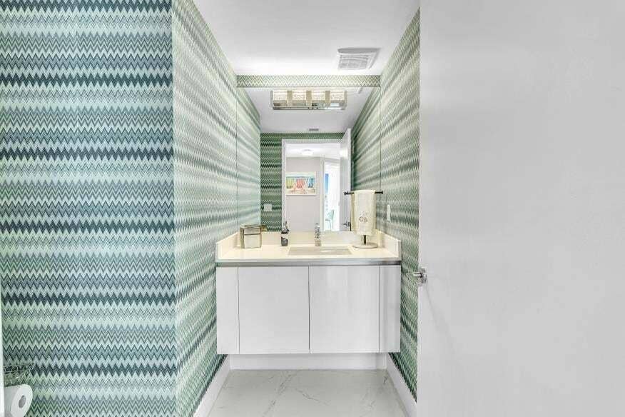 Sunny Isles Beach, Sunny Isles Beach, FL 33160 Floating vanity with a light-toned countertop, under-mount sink, and chevron-patterned wall covering