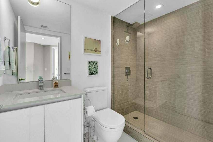 Sunny Isles Beach, Sunny Isles Beach, FL 33160 White vanity with a light-toned countertop, rectangular undermount sink, and a frameless mirror