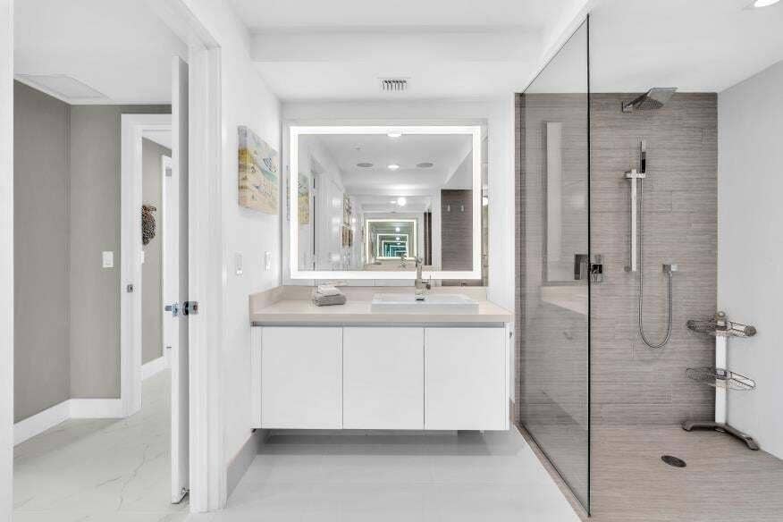Sunny Isles Beach, Sunny Isles Beach, FL 33160 Modern bathroom featuring a floating vanity with integrated sink, illuminated mirror, and a glass-enclosed shower with a rain showerhead