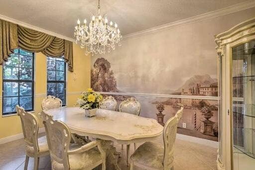 Elaborate crystal chandelier, scenic wall mural, crown molding, and a built-in display cabinet