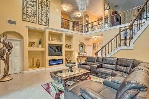 Two-story interior with a prominent staircase featuring dark wood handrails and wrought iron balusters
