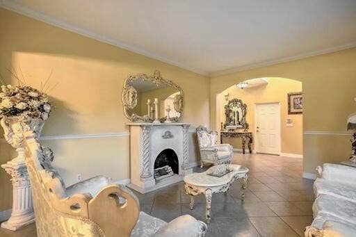 Ornate decorative fireplace with a mantel, crown molding, and tiled flooring