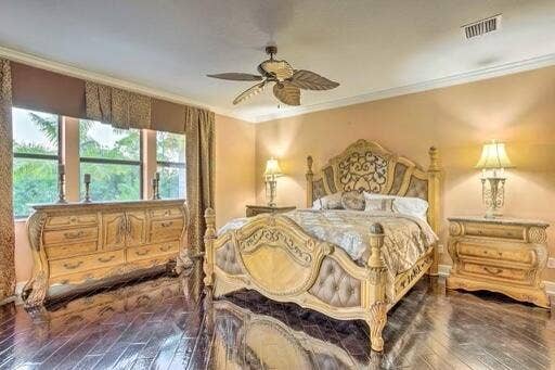 Hardwood flooring, crown molding, and large windows with privacy blinds