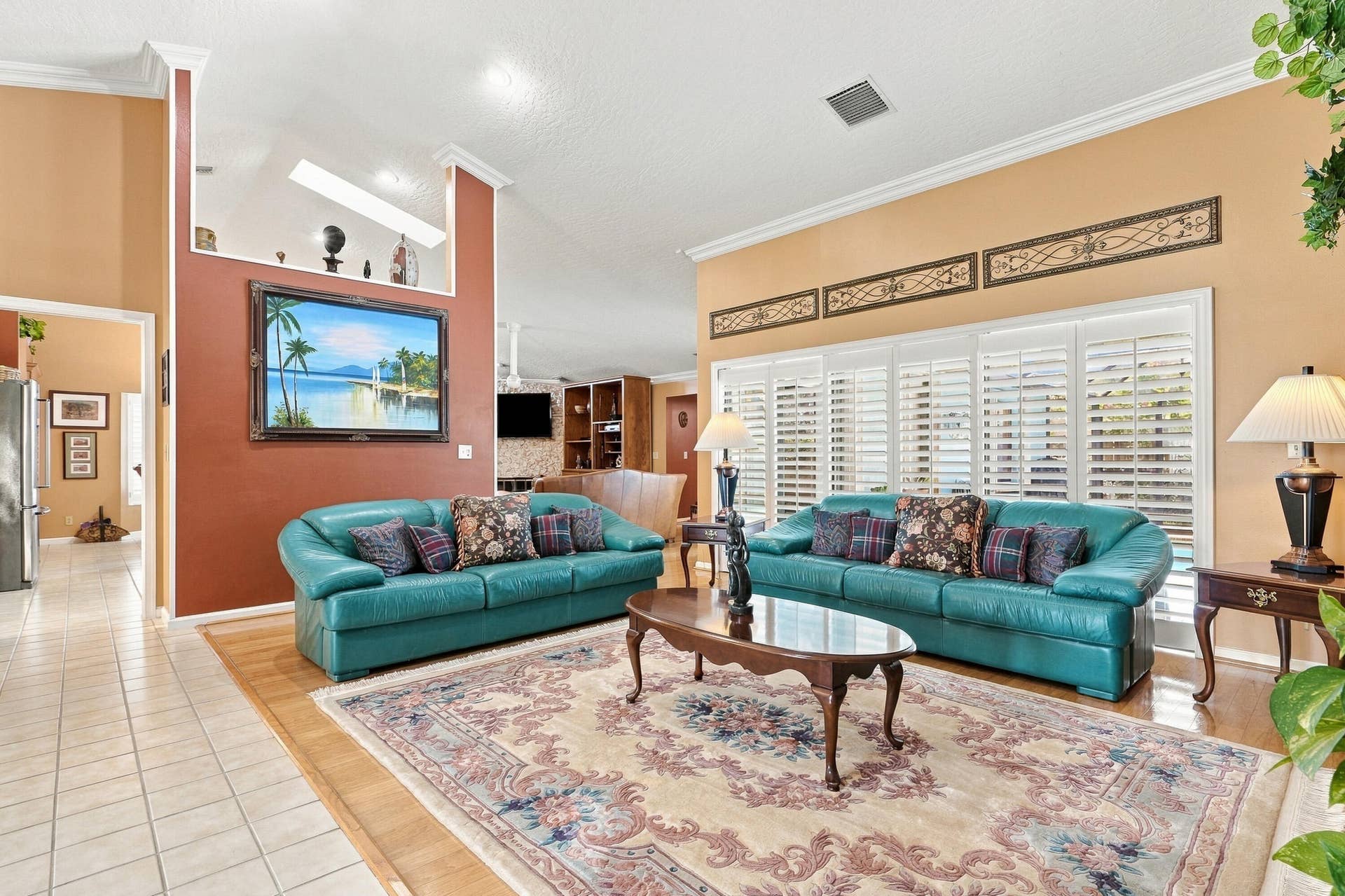 Vaulted ceiling, interior plantation shutters, tile flooring, wood-finish flooring, crown molding