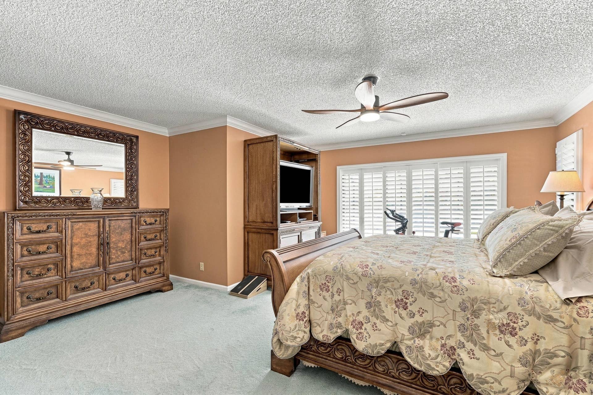 Built-in entertainment center, window shutters, crown molding, and ceiling fan
