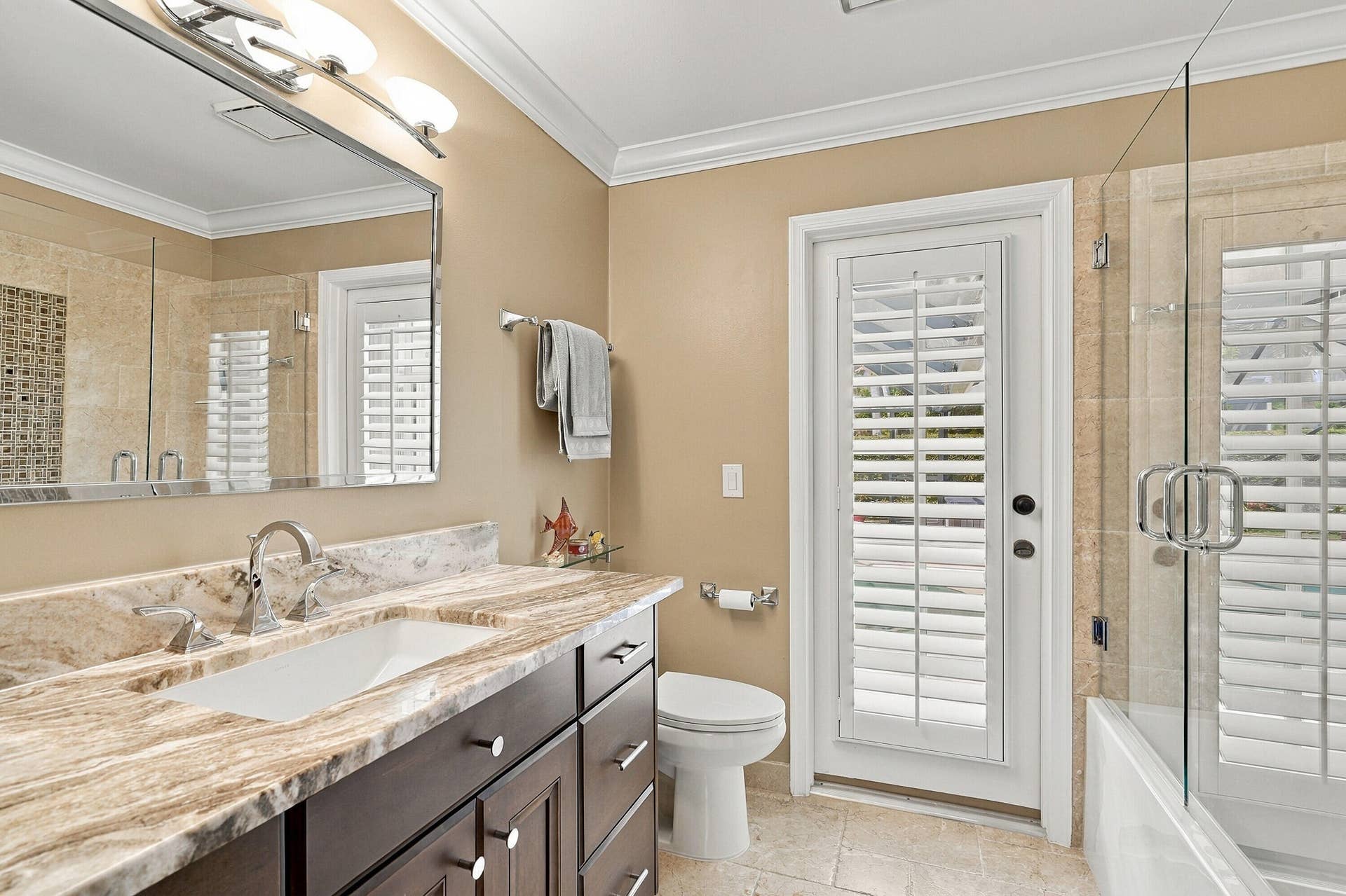 Vanity with an integrated sink, polished chrome fixtures, and a stone countertop