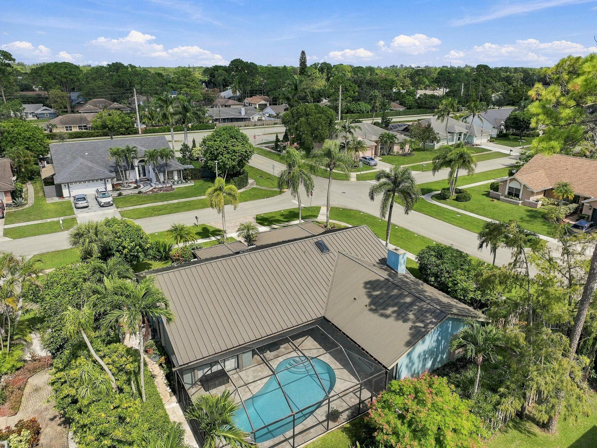 Screened-in pool, metal roof, mature landscaping, and an established neighborhood setting