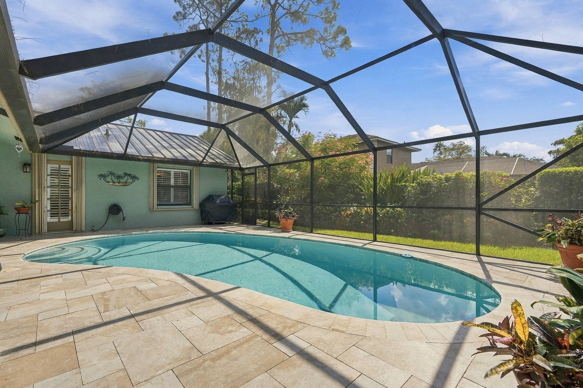 Screened lanai featuring a swimming pool with integrated steps