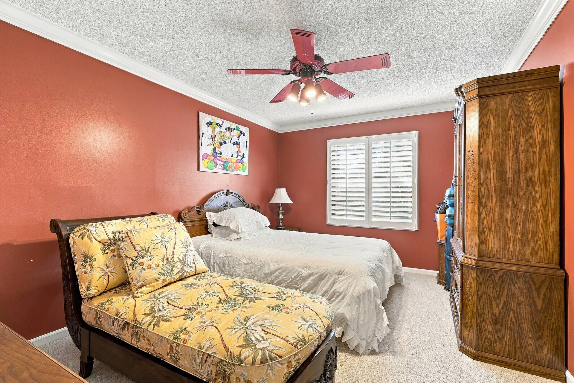 White crown molding, ceiling fan with integrated lighting, window with white plantation shutters, and light-colored textured carpeting