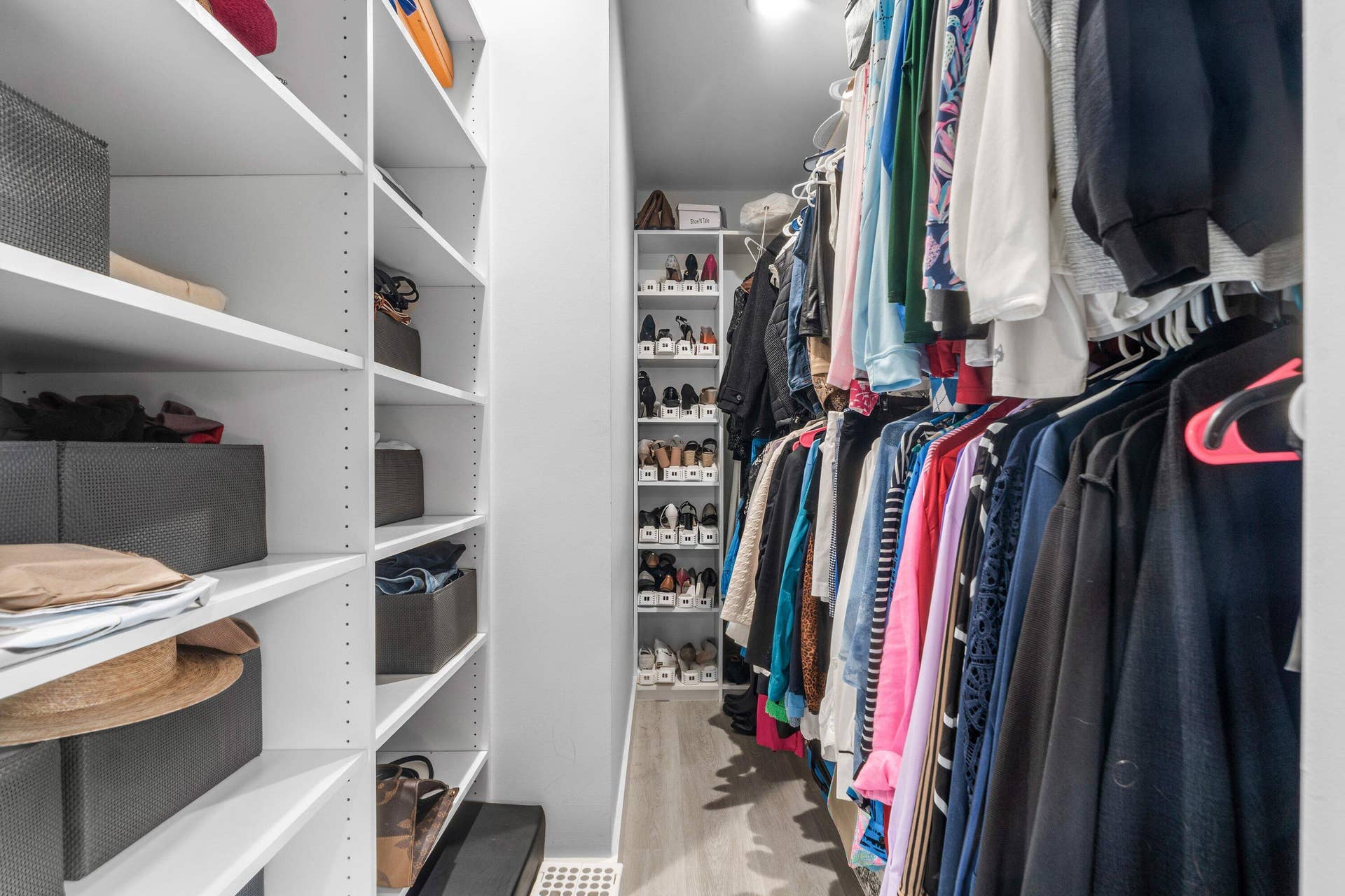 13138 Touchstone Place, Palm Beach Gardens, FL 33418 Walk-in closet featuring built-in shelving, hanging rods, recessed lighting, and wood-finish flooring