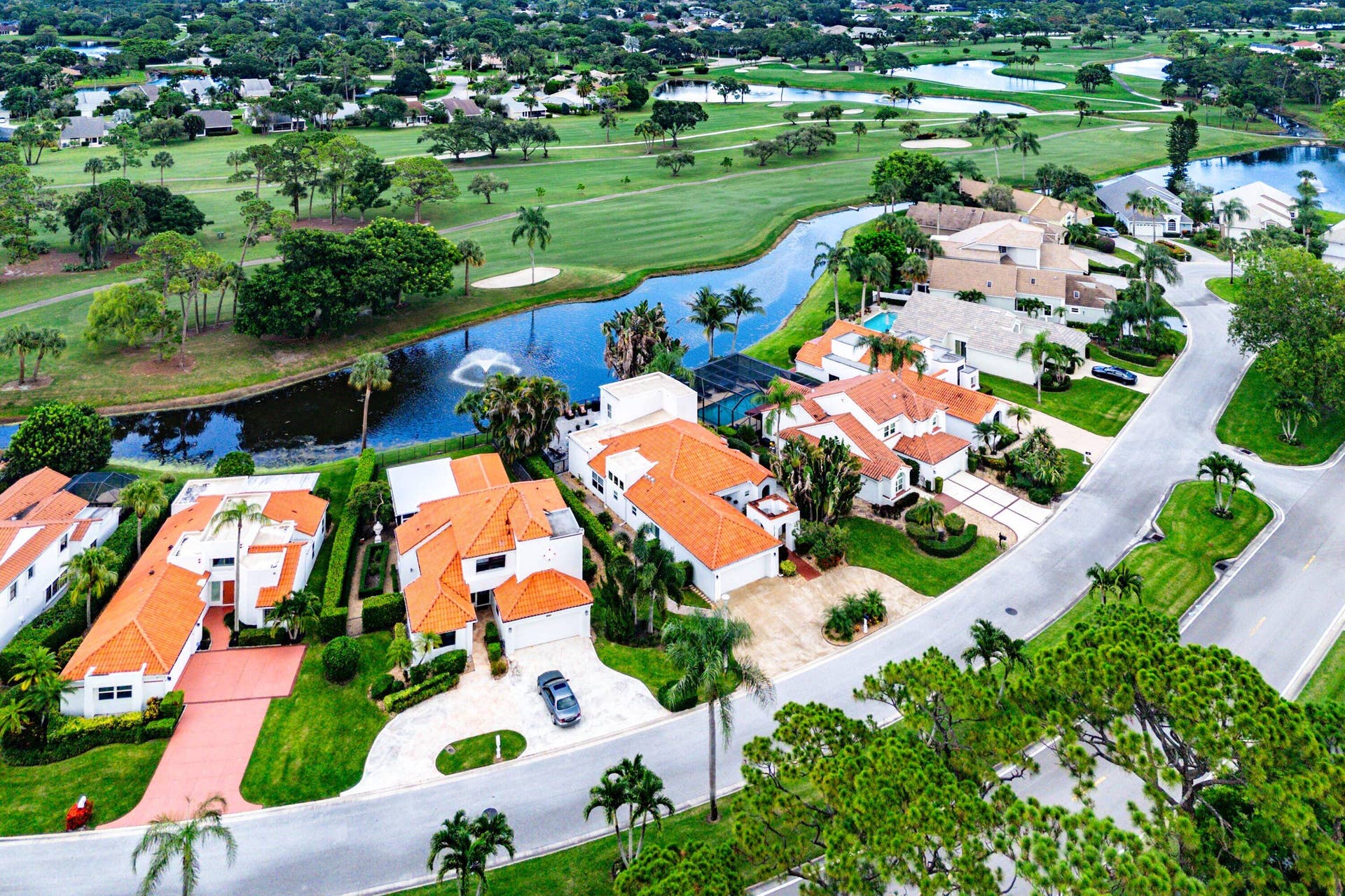 13138 Touchstone Place, Palm Beach Gardens, FL 33418 Aerial perspective showcasing a residential community with lush landscaping, a golf course, and water features