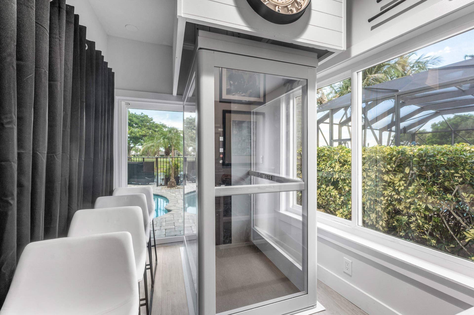 13138 Touchstone Place, Palm Beach Gardens, FL 33418 Built-in glass elevator, large windows, wood-finish flooring, and exterior landscaping