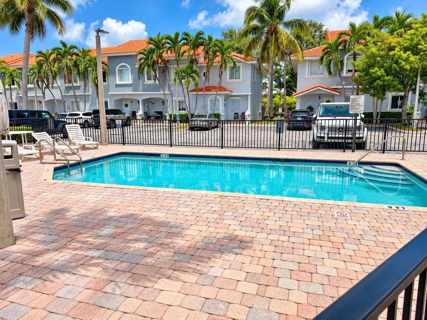 Rectangular swimming pool with integrated steps, surrounded by a paver patio. Virtually staged.