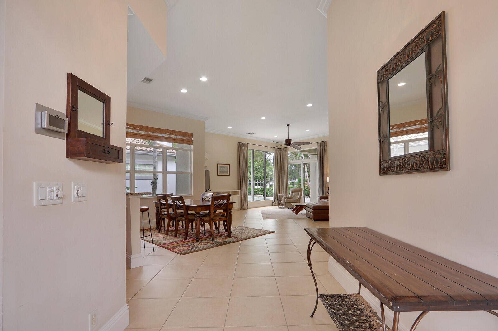 Vaulted ceiling, recessed lighting, tile flooring, and a ceiling fan