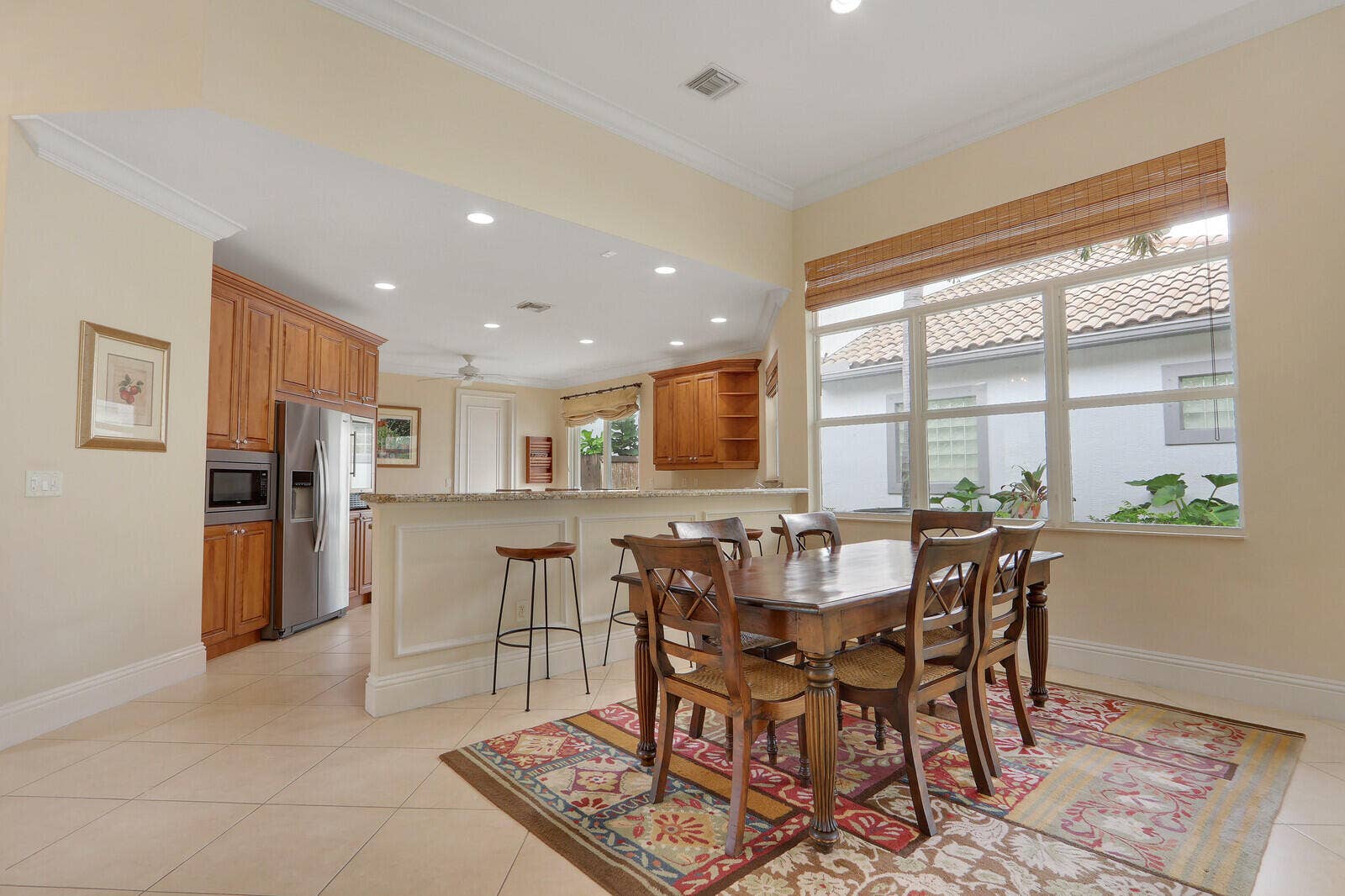 Tile flooring throughout, crown molding, a built-in breakfast bar, recessed lighting, and a large multi-pane window