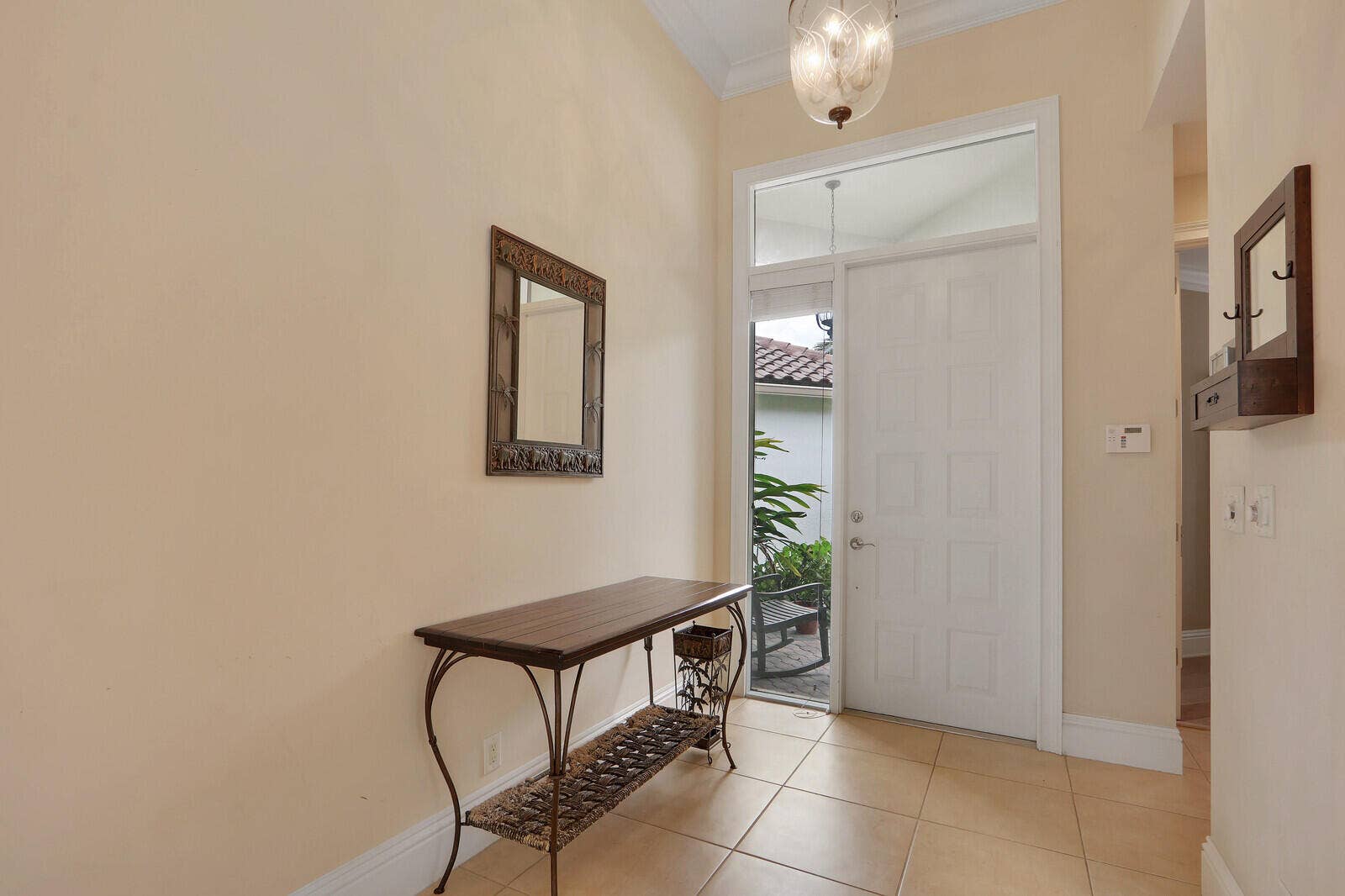 Entryway with tile flooring, a paneled door, and transom window