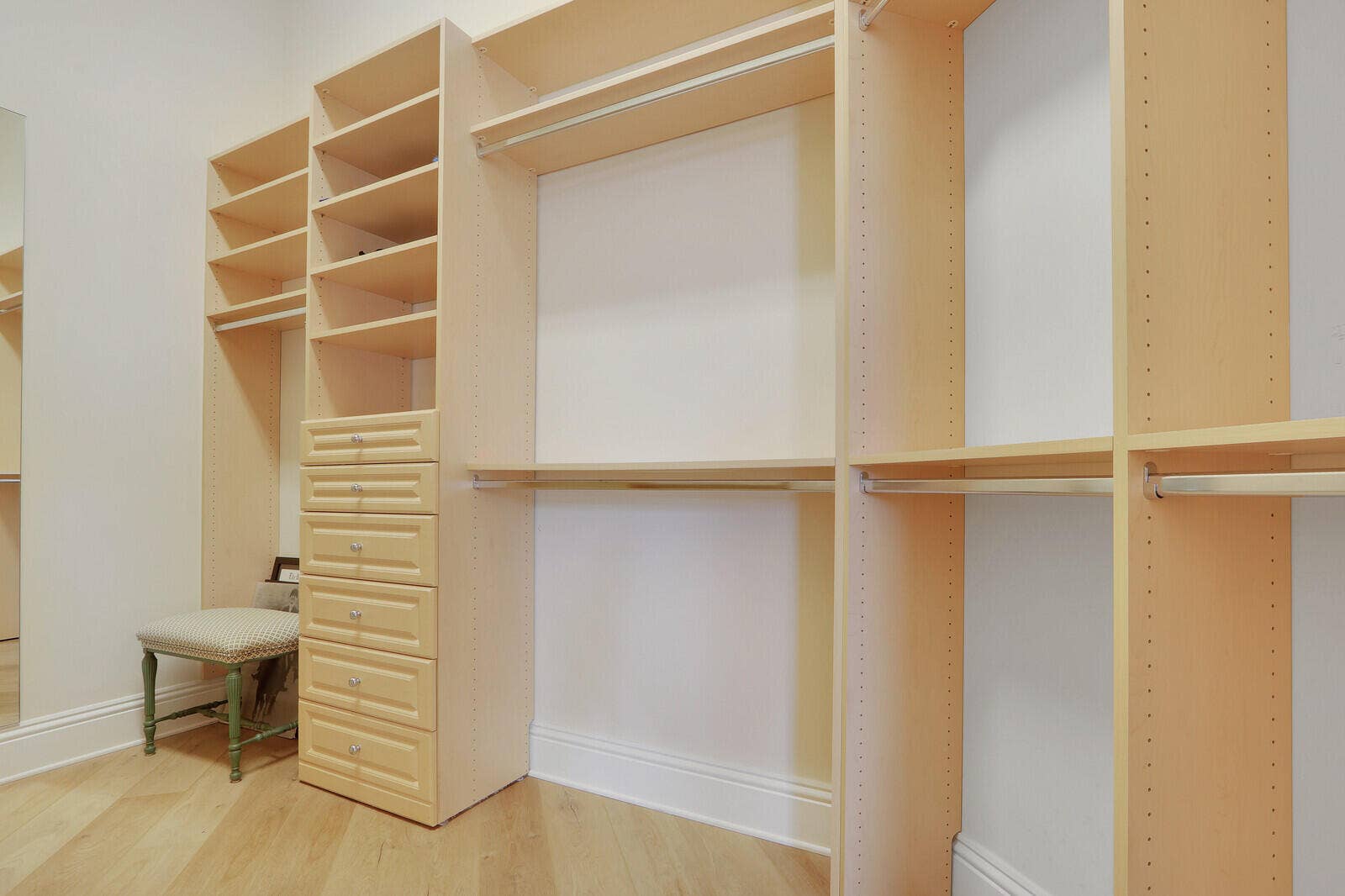 Custom closet system featuring extensive shelving, built-in drawers, and multiple hanging rods