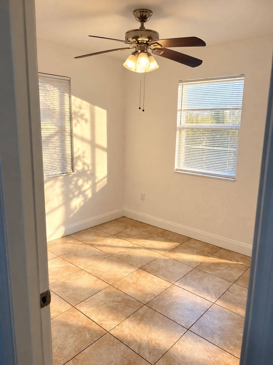 Sunlit Empty Room with Ceiling Fan