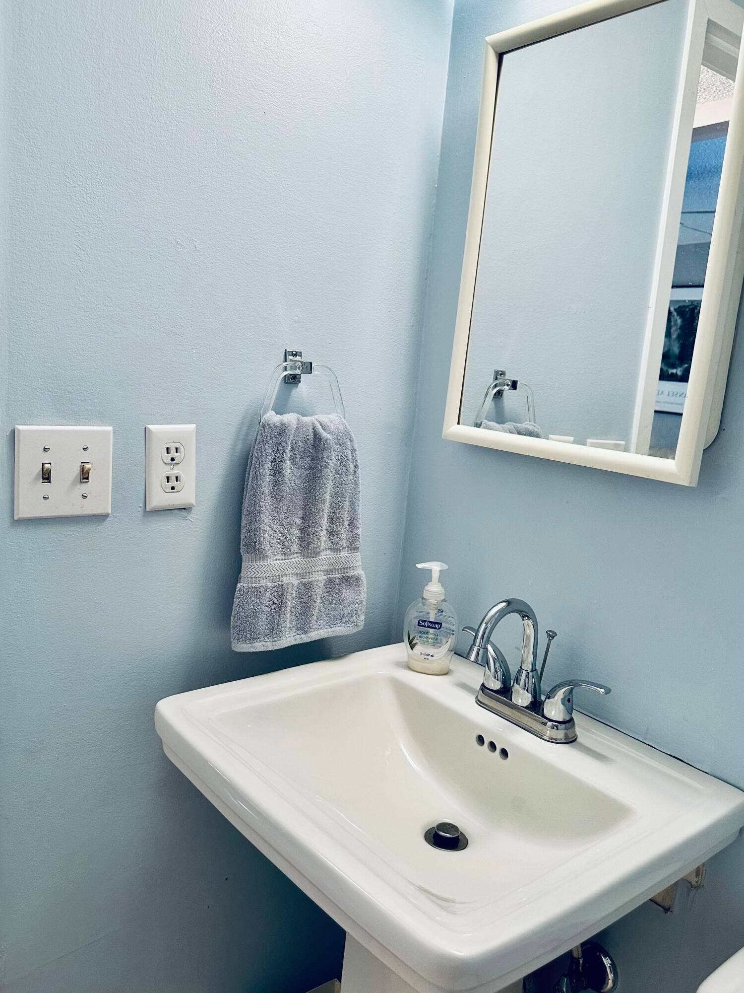 2950 SE Ocean Boulevard, #130-6, Stuart, FL 34996 Pedestal sink with a chrome faucet, medicine cabinet, and light blue walls