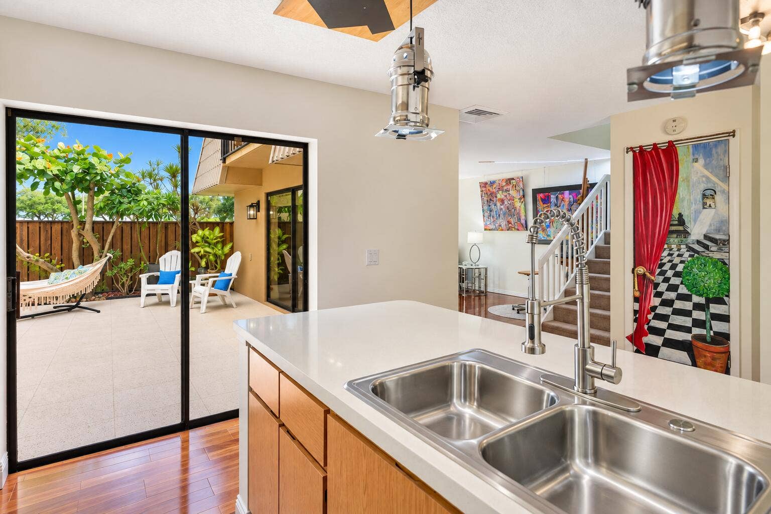 Kitchen island with a double basin stainless steel sink, a pull-down faucet, and wood-finish cabinetry