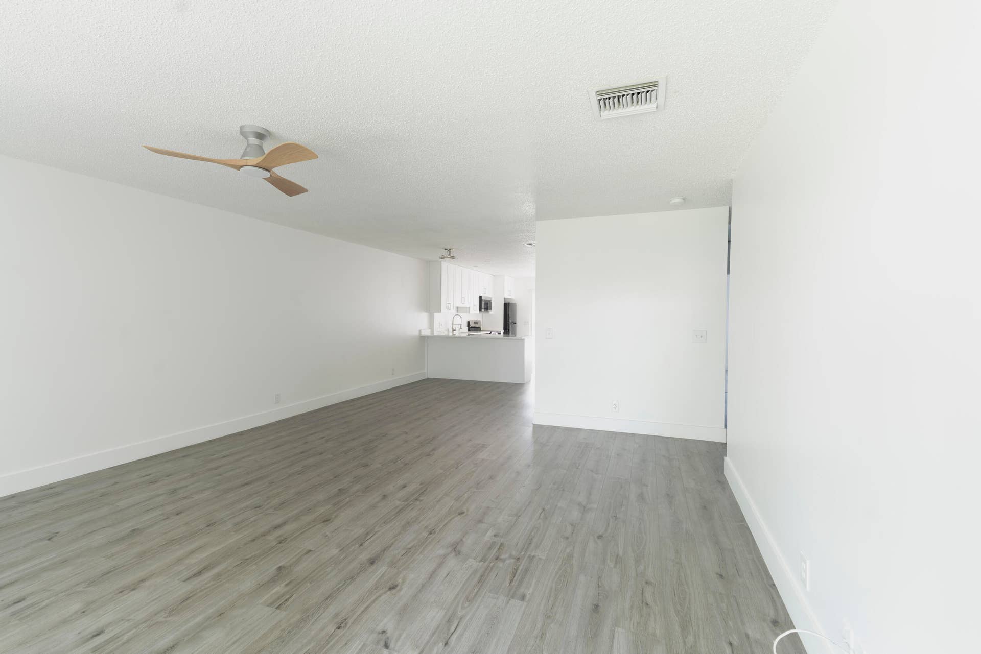 Spacious room featuring vinyl wood like flooring, a modern ceiling fan, and recessed lighting