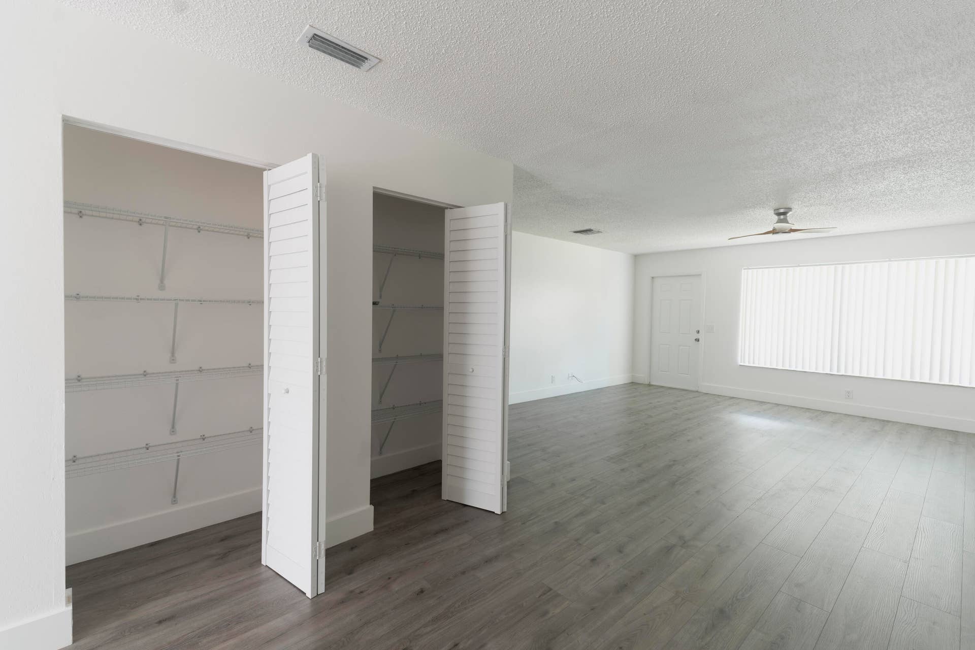 Light-toned vinyl wood like flooring complements the neutral wall palette