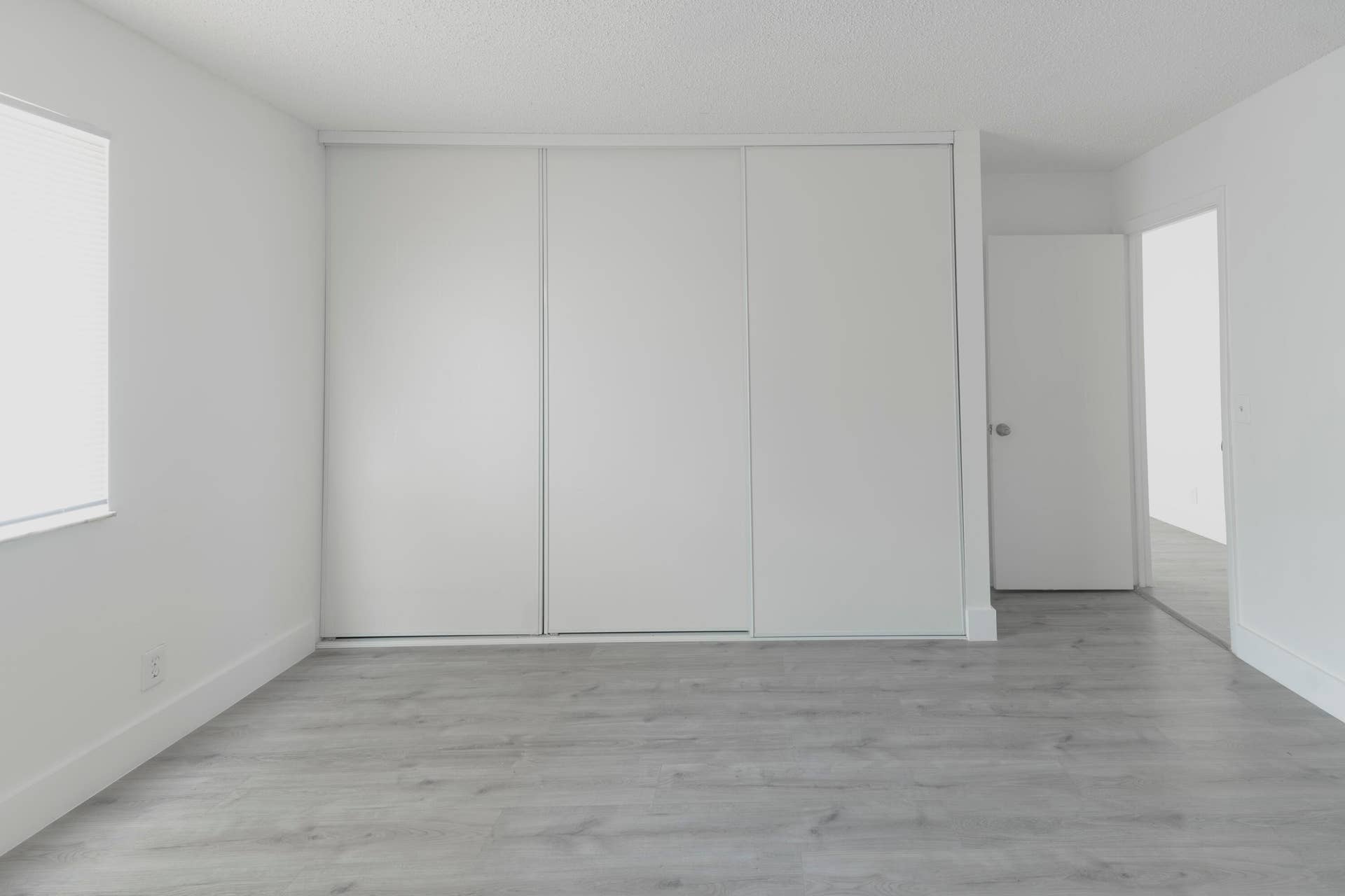 Light-toned vinyl wood like flooring complements white walls and trim