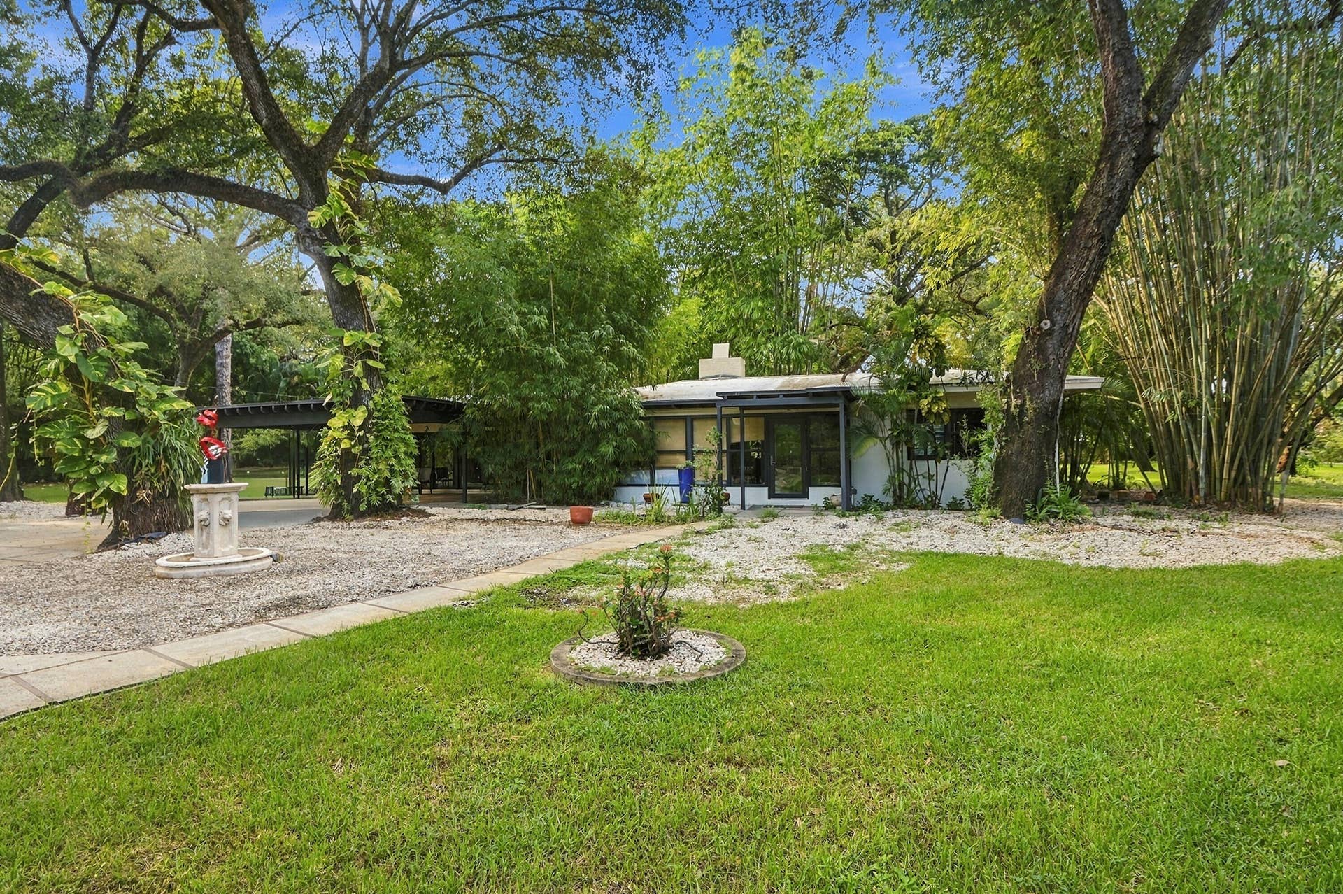 1549 SW 30th Place, Fort Lauderdale, FL 33315 Contemporary-style residence with a flat roofline, surrounded by mature trees and dense bamboo