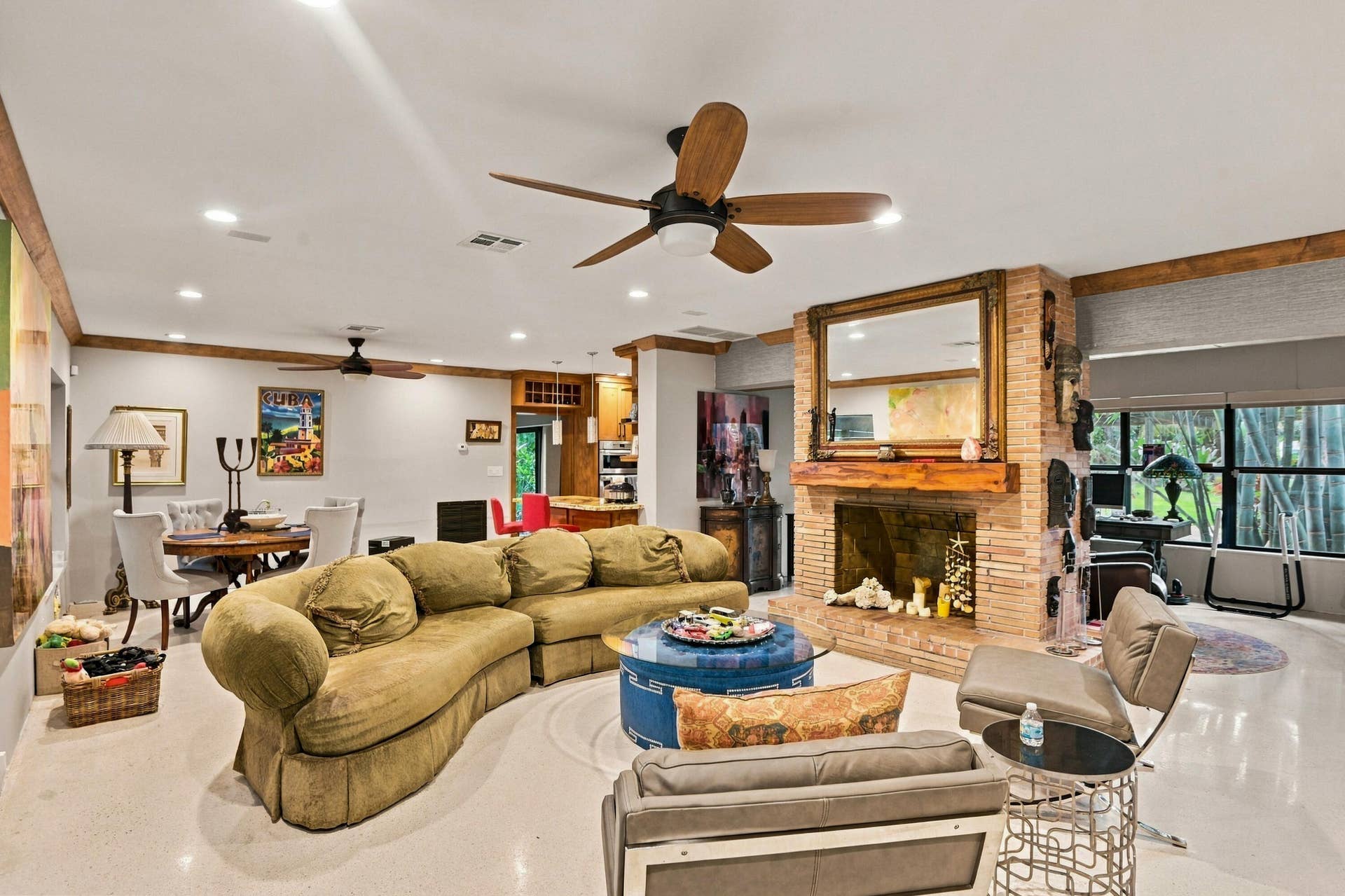 1549 SW 30th Place, Fort Lauderdale, FL 33315 Spacious living area featuring a brick fireplace, wood mantel, and multiple ceiling fans