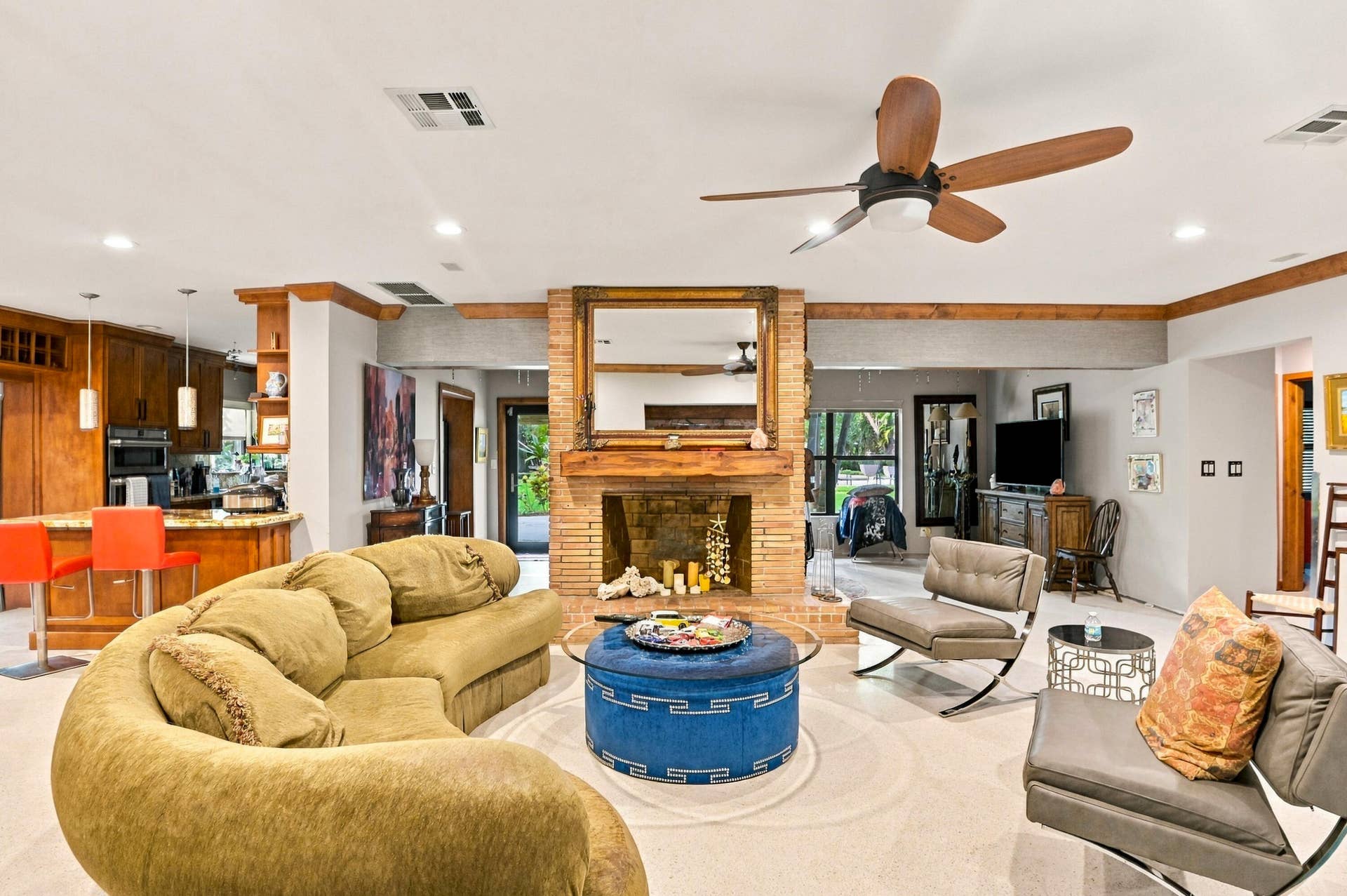 1549 SW 30th Place, Fort Lauderdale, FL 33315 Spacious living area featuring a brick fireplace, wood-beam accents, and a ceiling fan