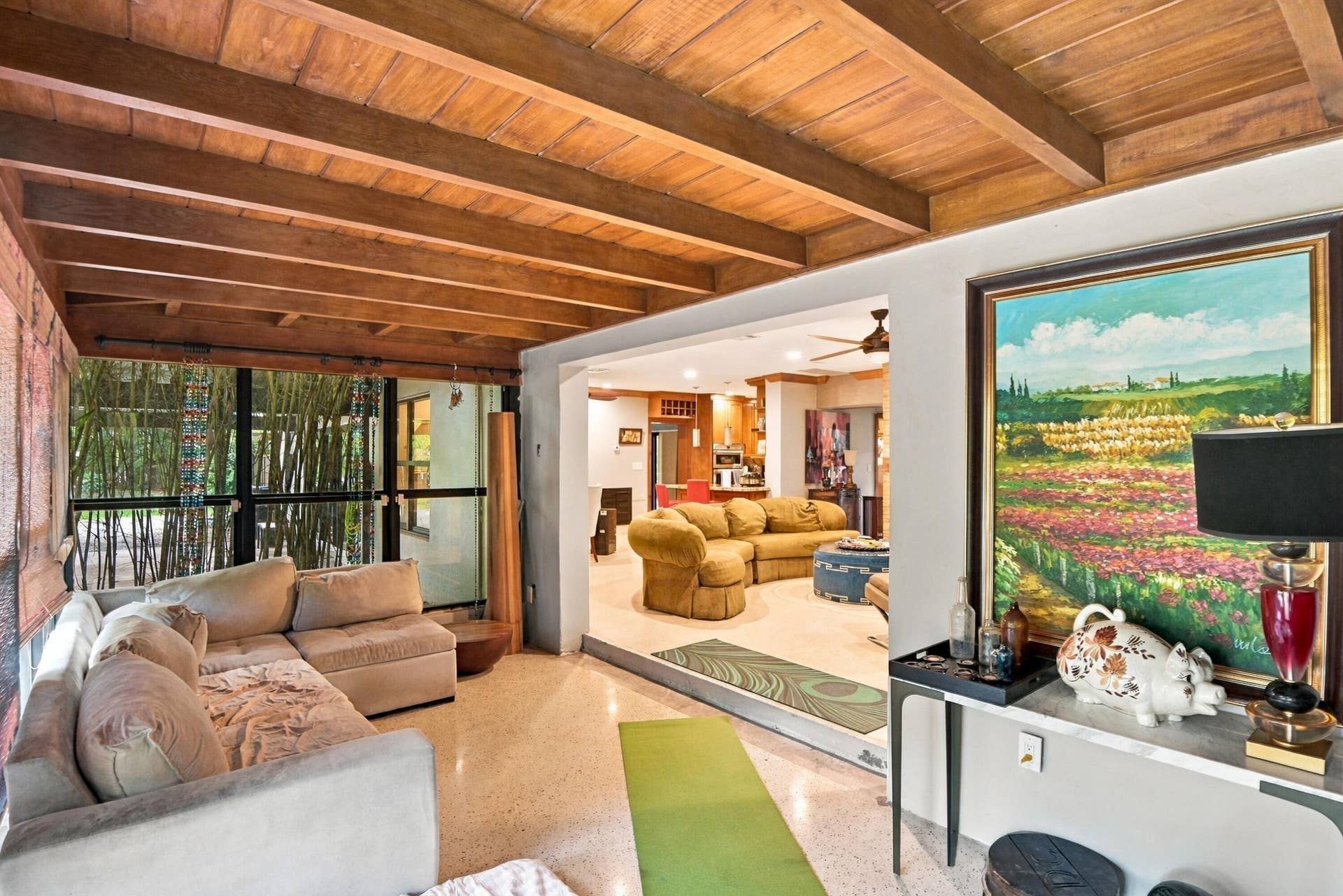1549 SW 30th Place, Fort Lauderdale, FL 33315 Exposed wood beam ceiling, expansive glass doors, polished terrazzo flooring, interior wall paneling, and a built-in console table