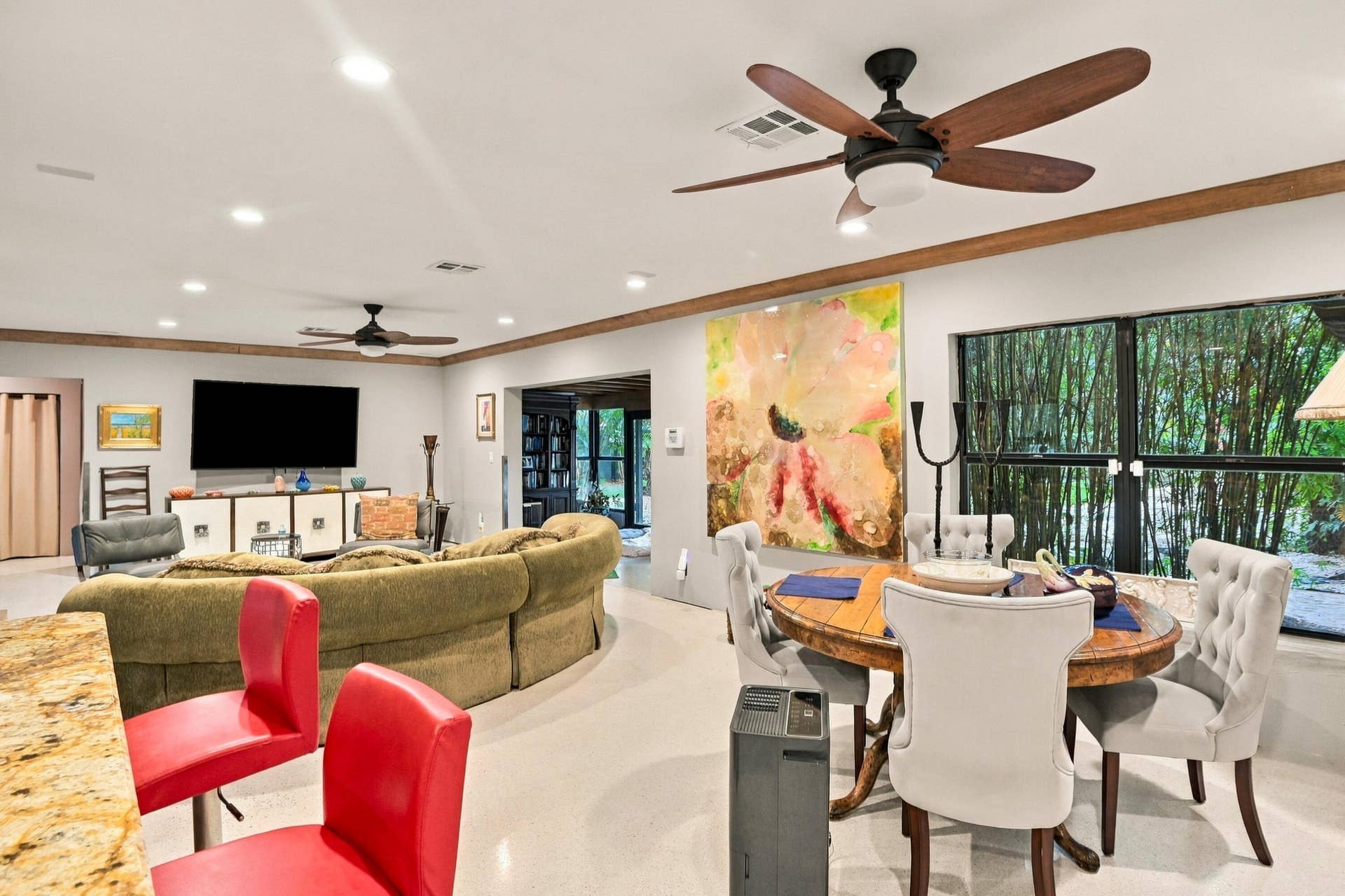 1549 SW 30th Place, Fort Lauderdale, FL 33315 Recessed lighting and ceiling fans illuminate the open-concept living space, featuring wood-finish ceiling beams