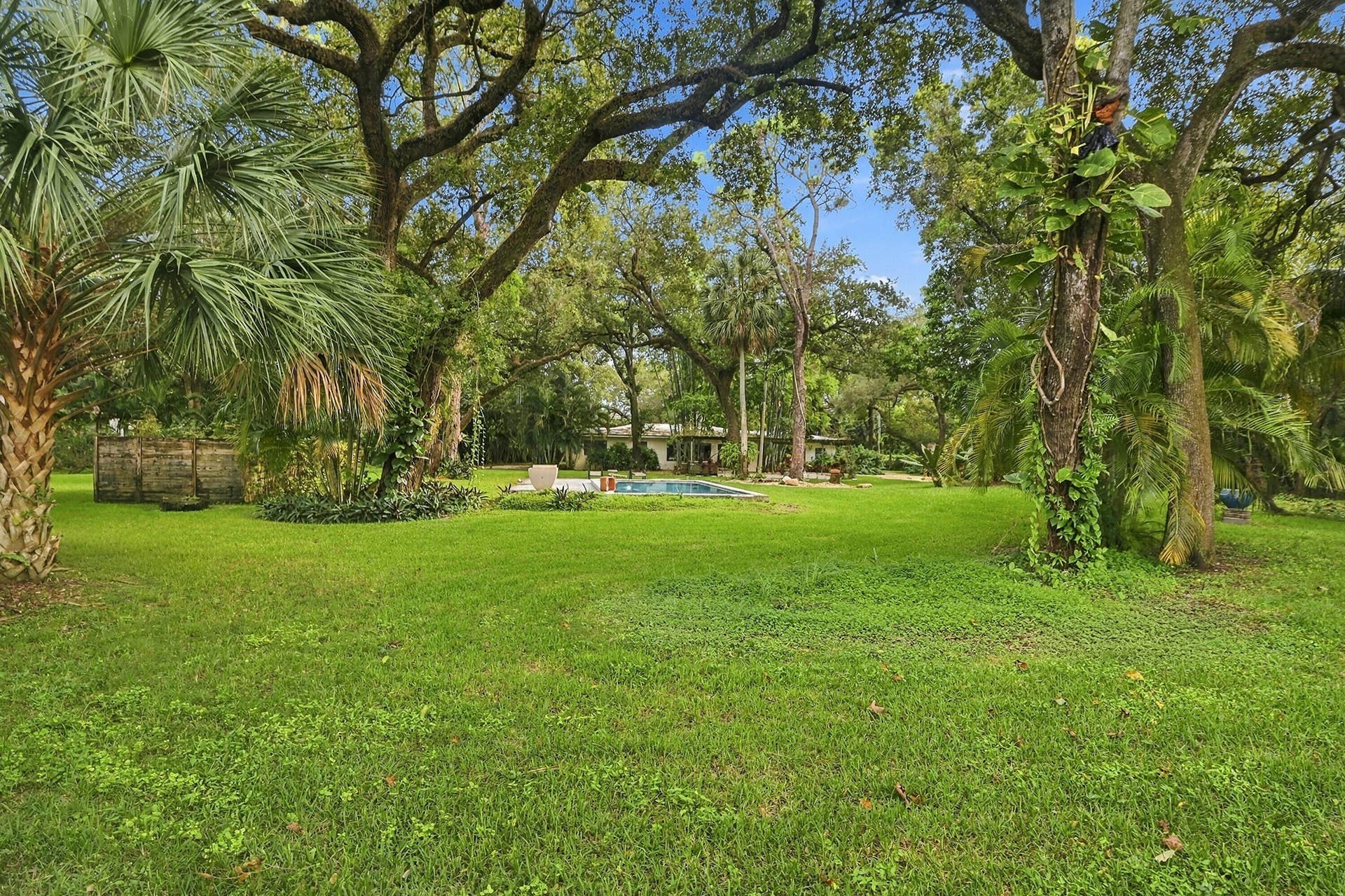 1549 SW 30th Place, Fort Lauderdale, FL 33315 Expansive lawn with mature trees, established landscaping, and a visible swimming pool