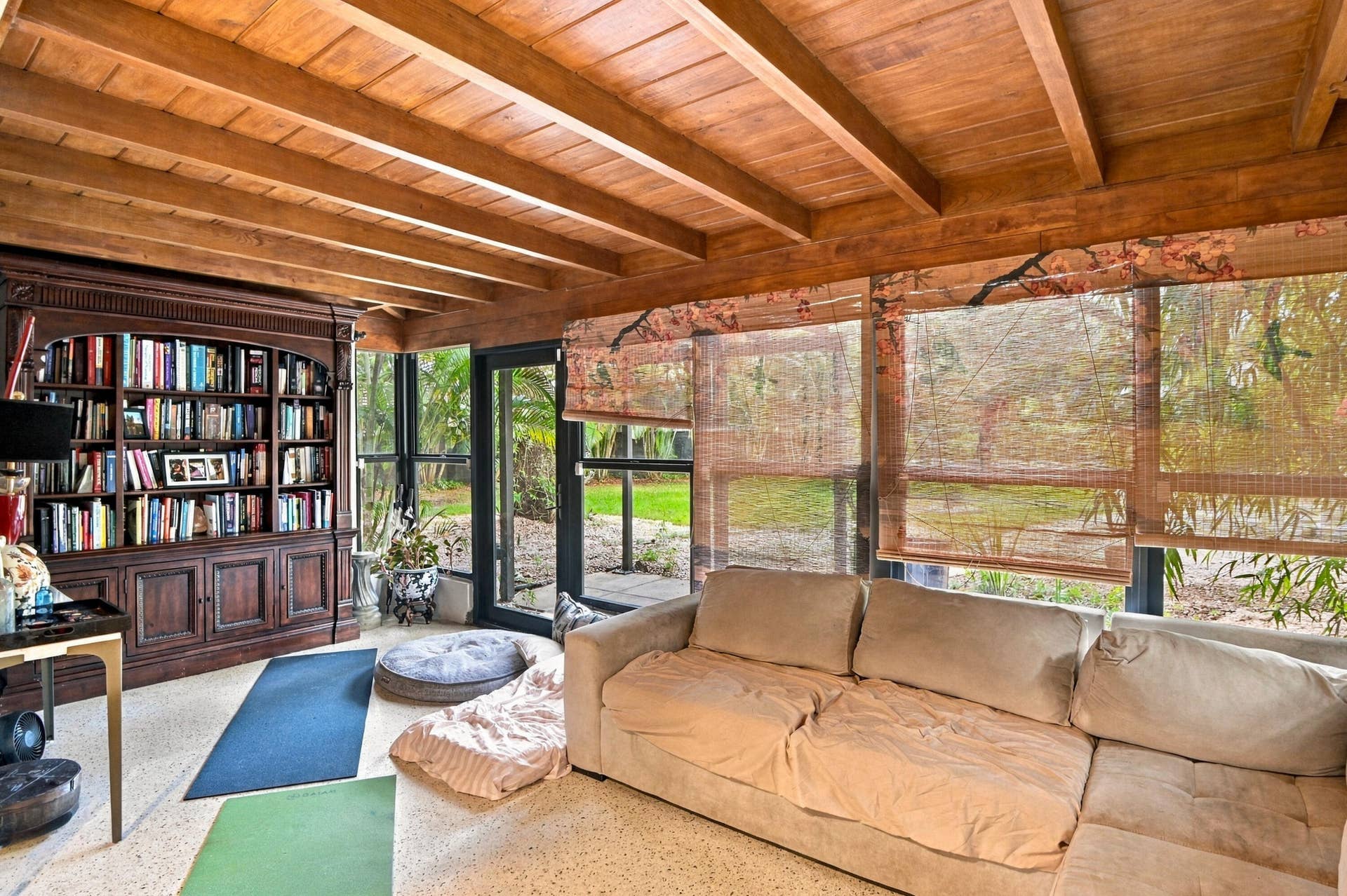 1549 SW 30th Place, Fort Lauderdale, FL 33315 Exposed wood beam ceiling, full-height built-in shelving, expansive windows, glass-paneled door, and terrazzo flooring